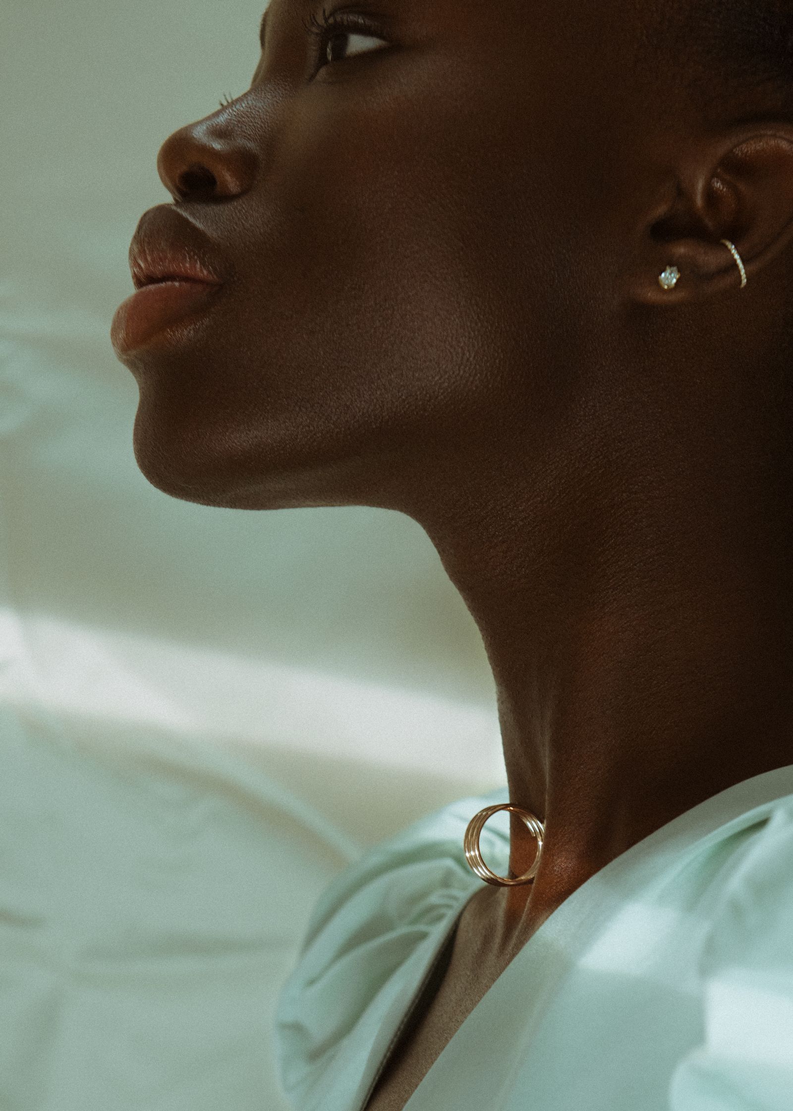 a black woman wearing a necklace and earrings