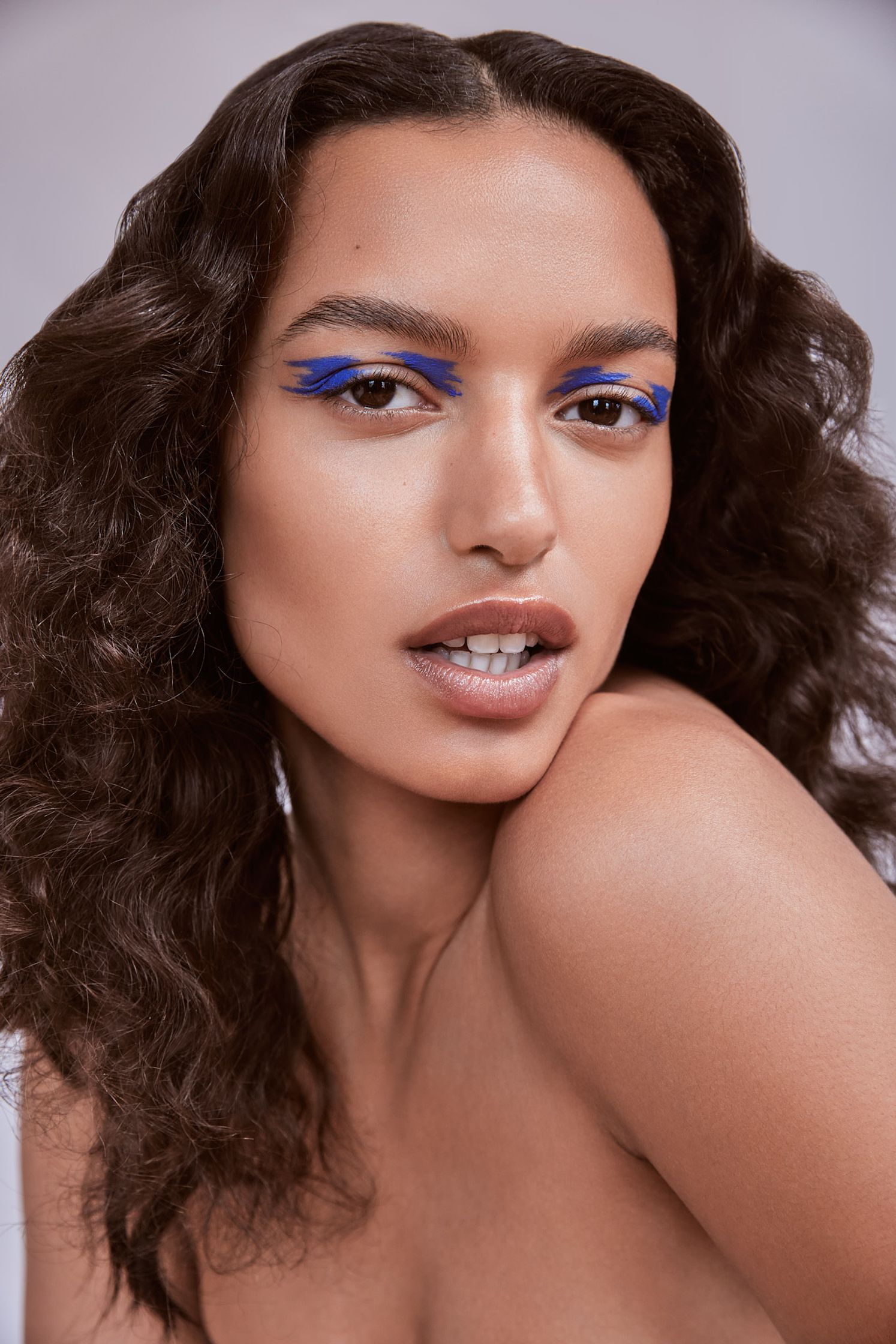 a woman with blue eye makeup posing for a photo