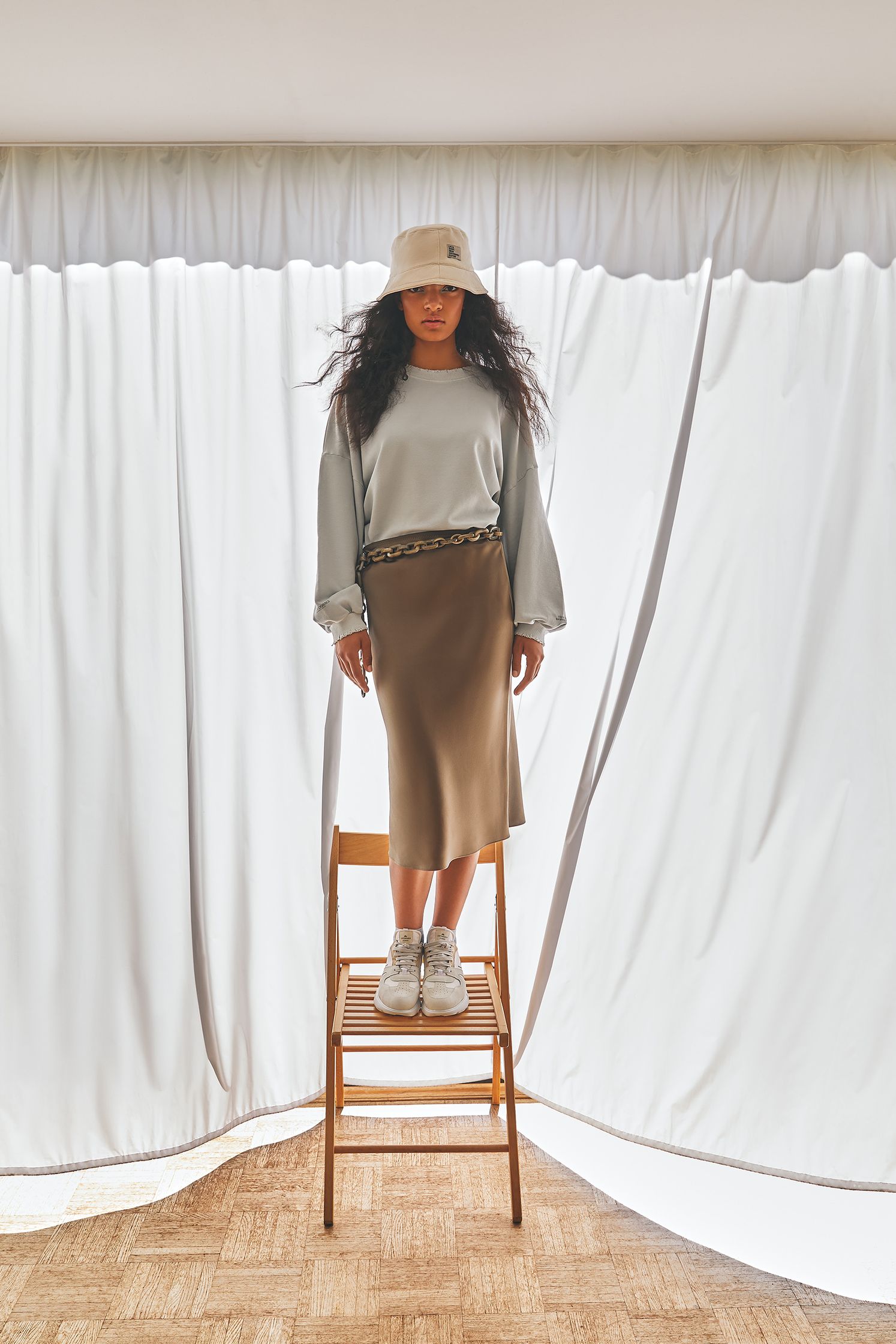 a woman standing on a chair in front of a curtain