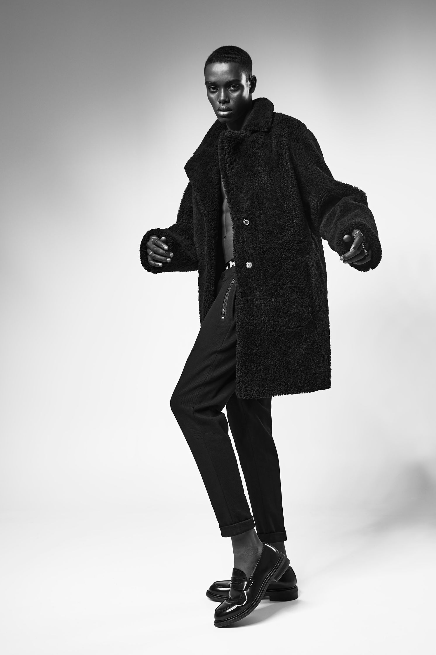 a black and white photo of a man in a fur coat