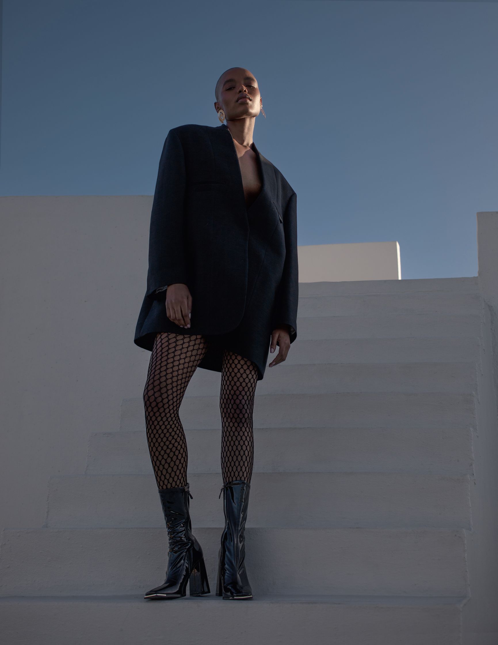 a woman in a black coat standing on a set of stairs