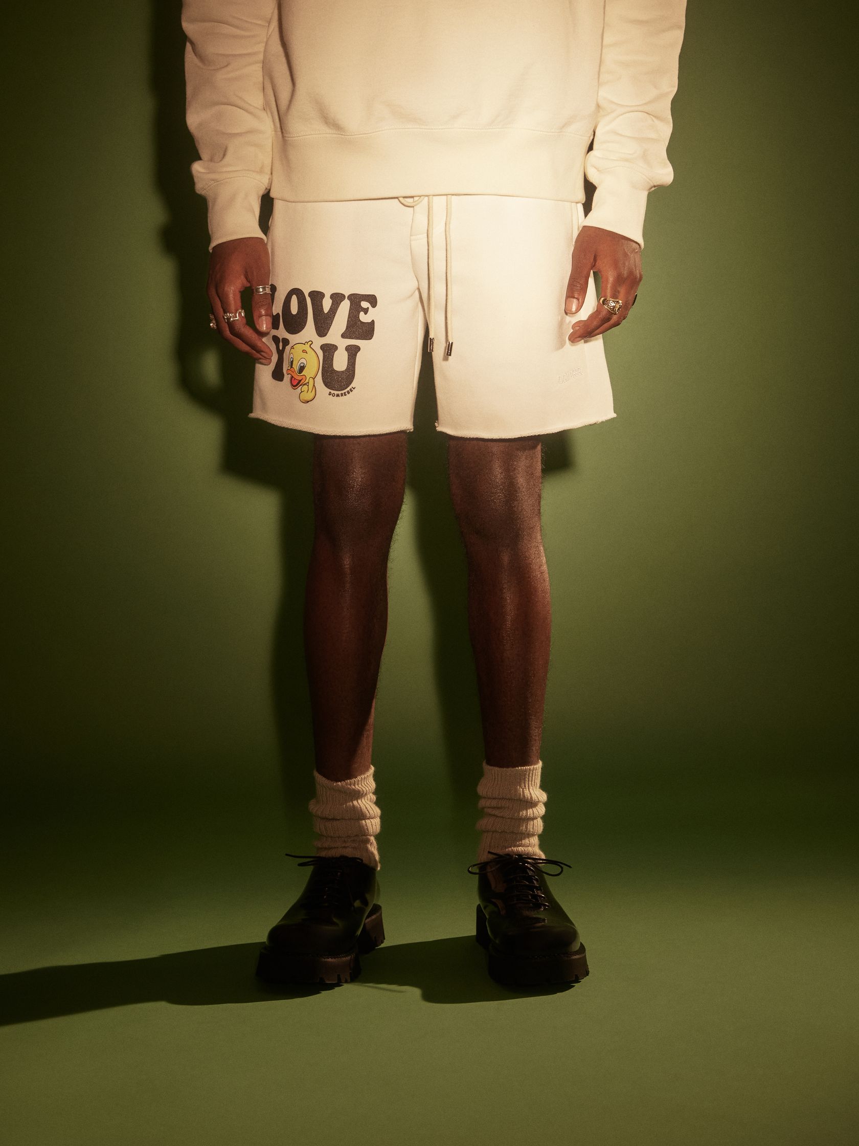 a man wearing a sweatshirt and shorts with the words love you