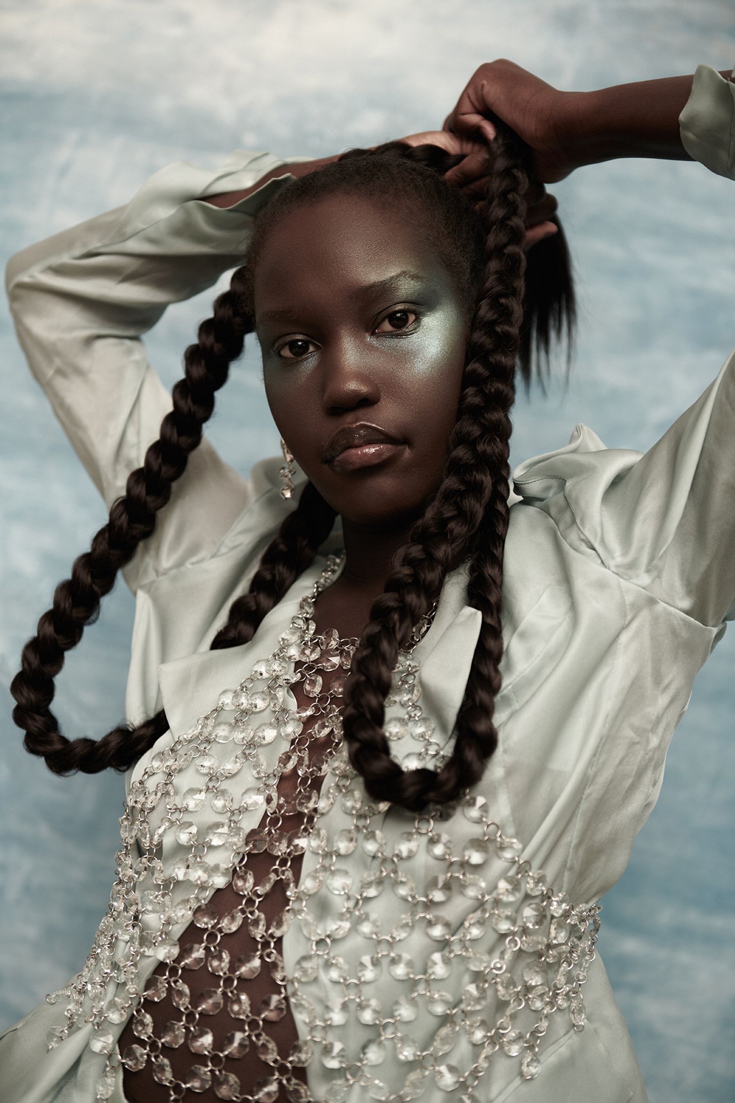 a black woman with braids posing on a blue background