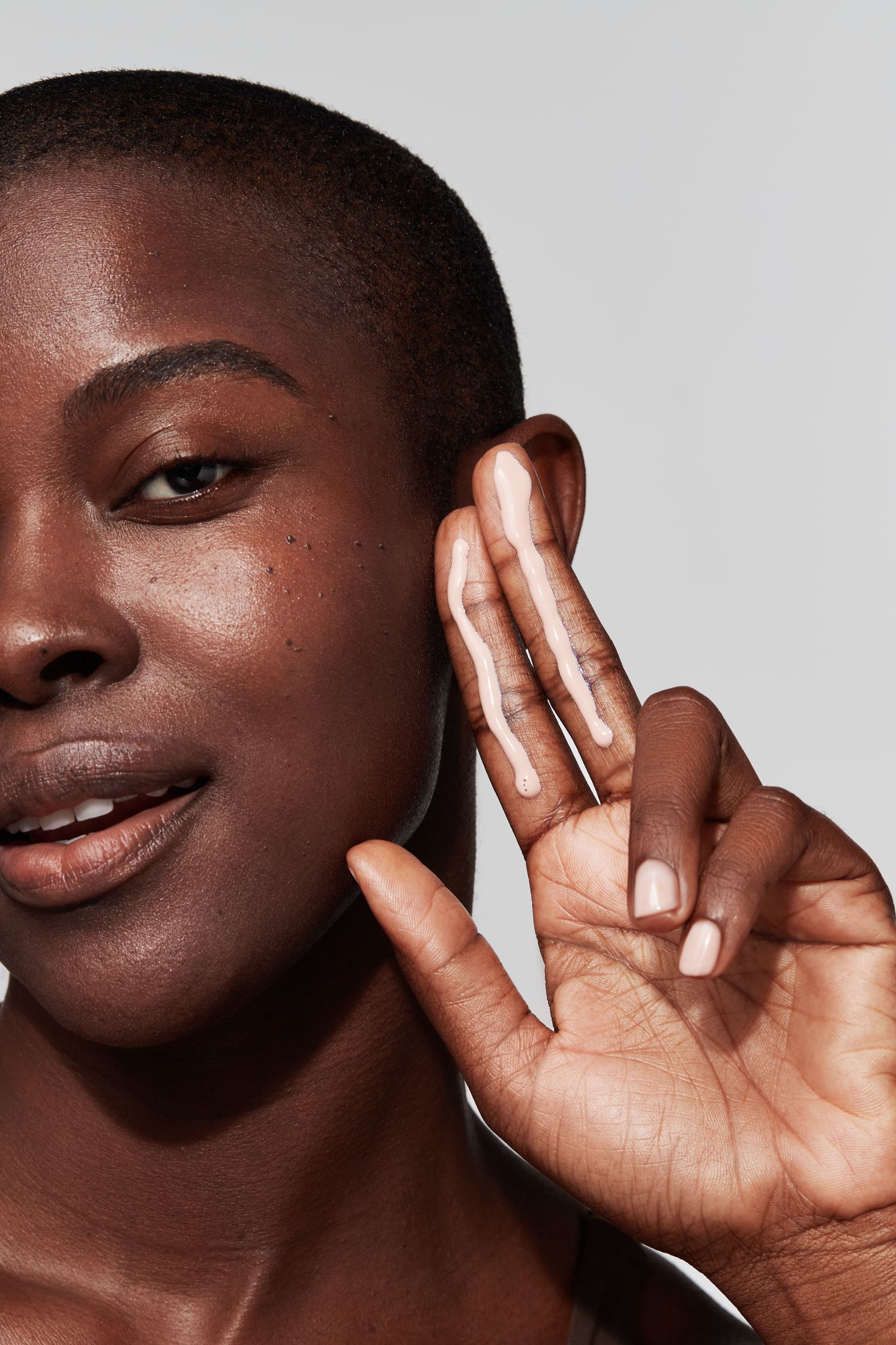 a black woman is holding her hand up to her face