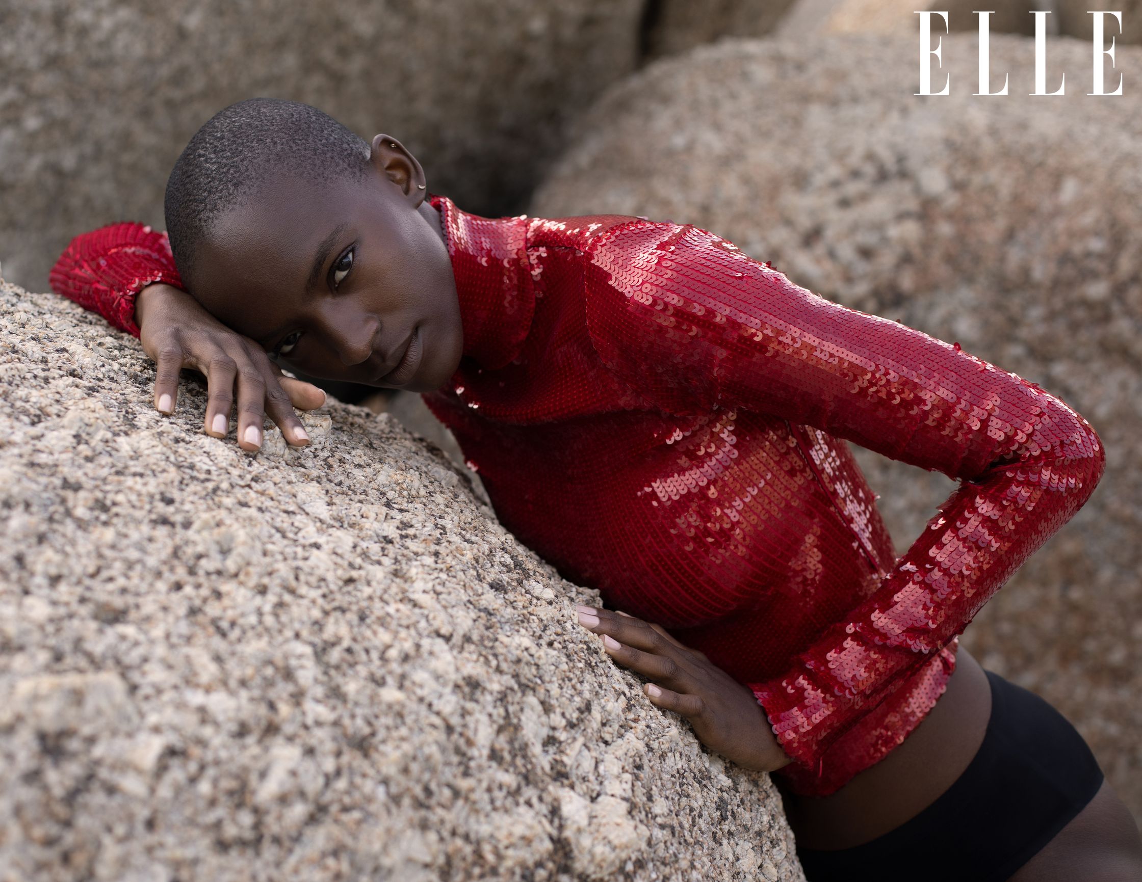 a woman in a red top posing on rocks