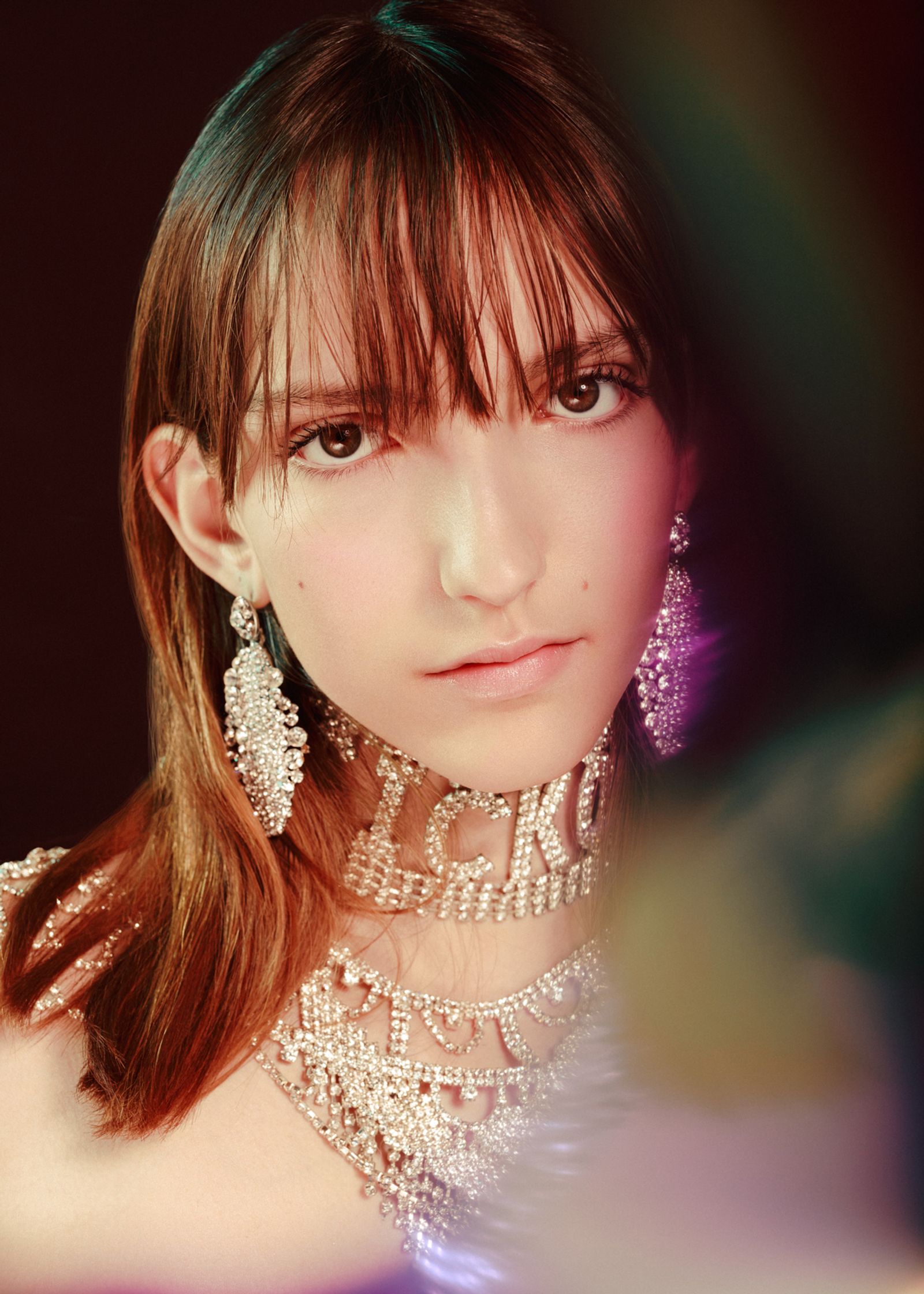 a woman with a necklace and earrings posing for a photo