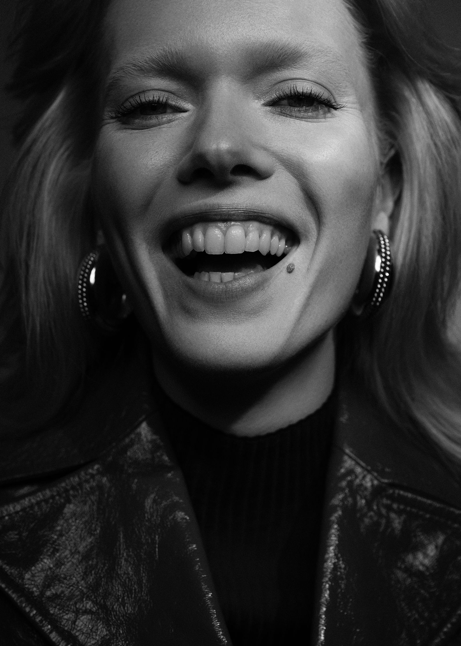 a black and white photo of a woman laughing