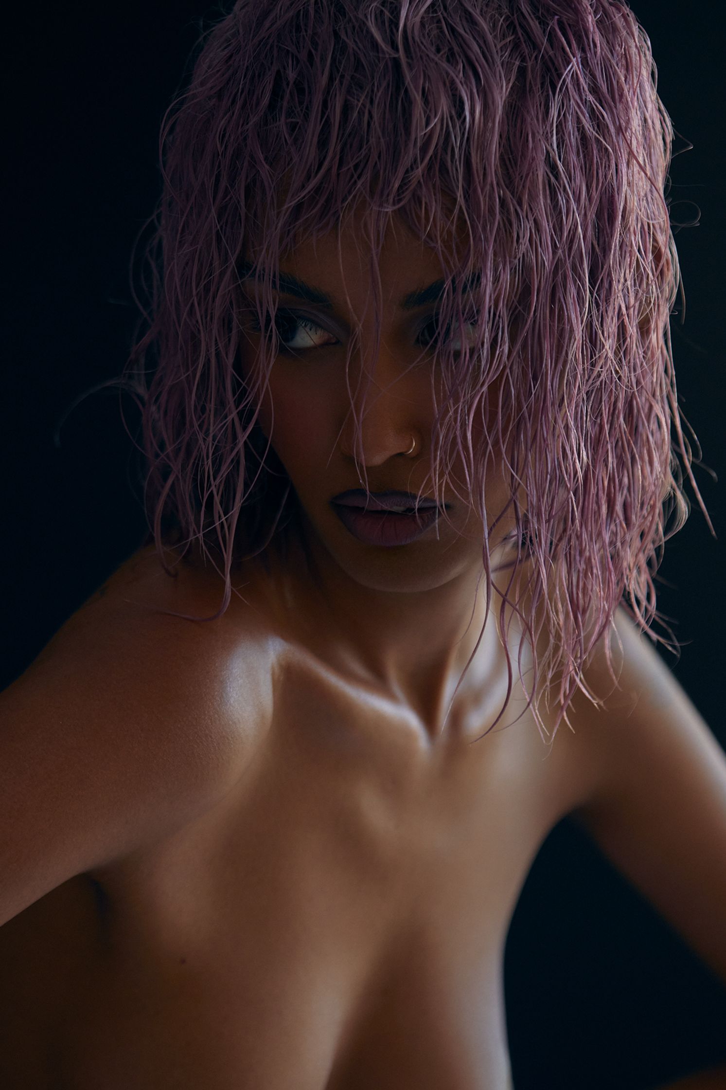 a woman with pink hair posing on a black background
