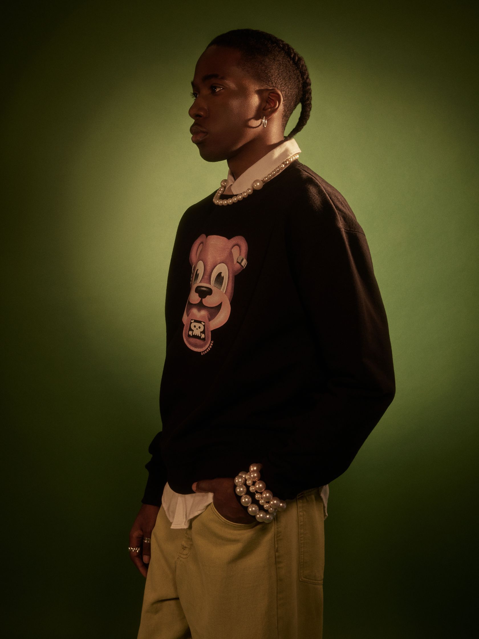 a young man wearing a sweater with a teddy bear on it