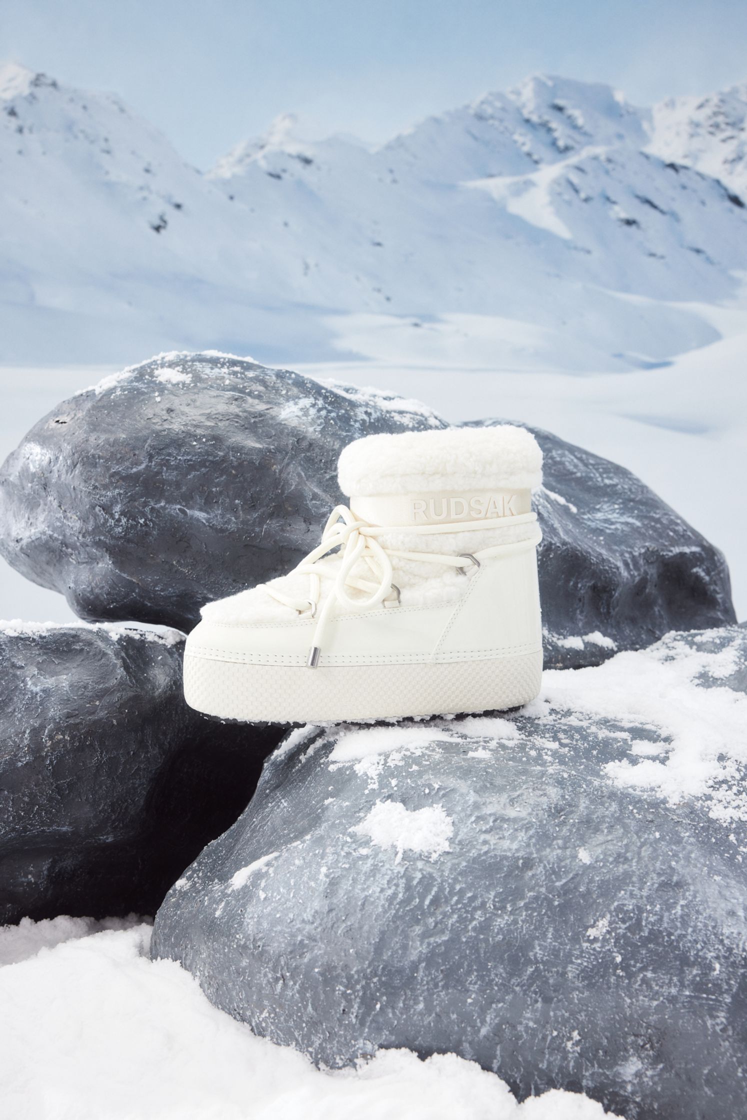 a pair of white snow boots on a rock in the snow