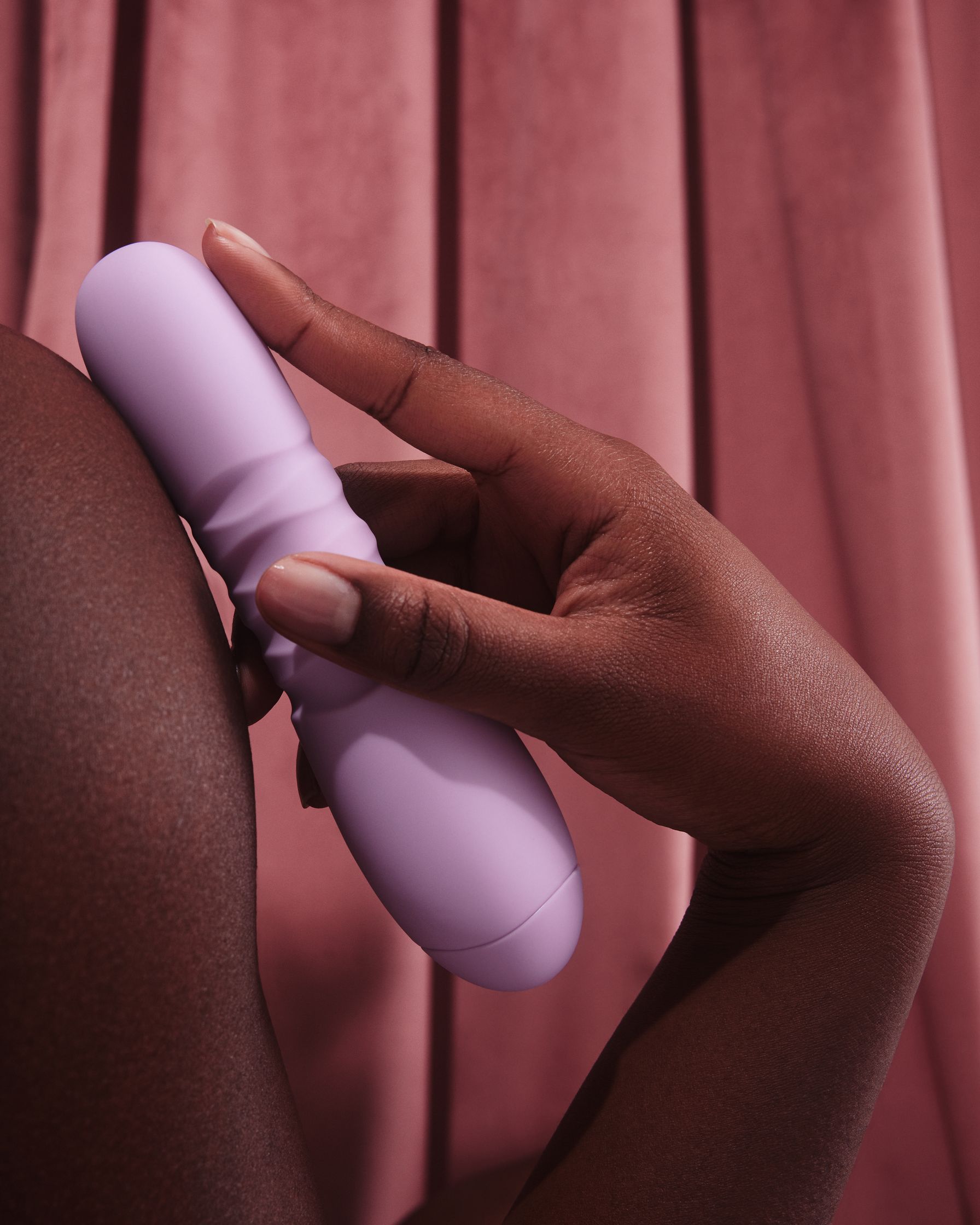 a woman's hand holding a purple vibrating toy