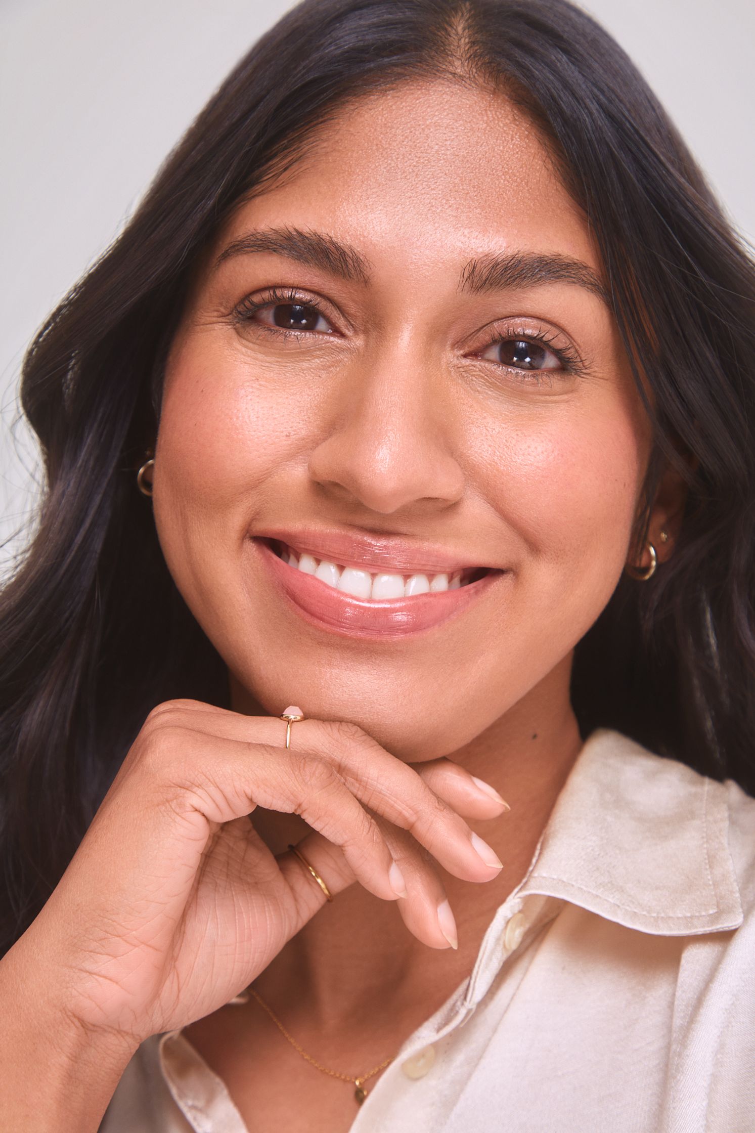 a woman smiling with her hand on her chin