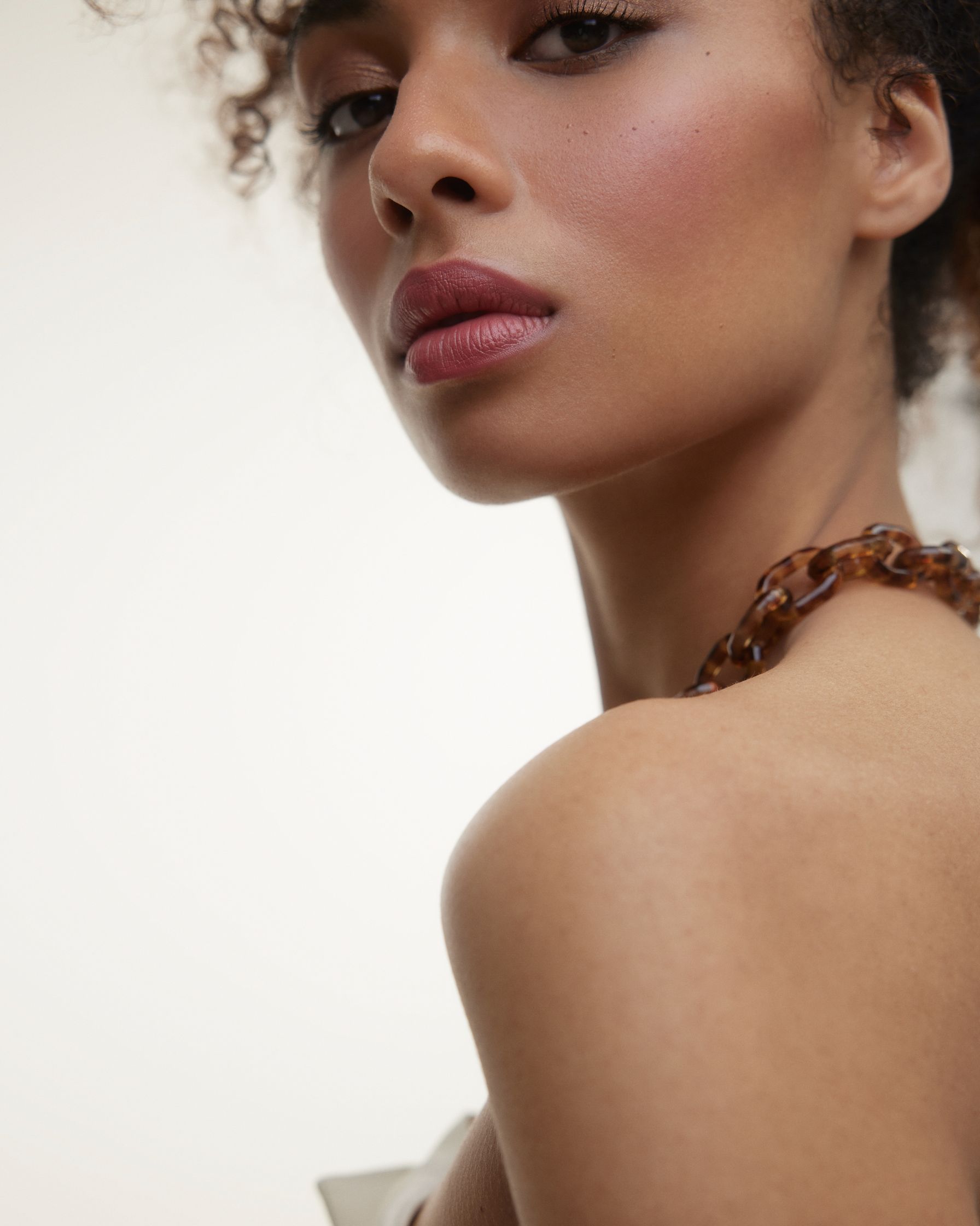 a woman with curly hair is posing for a photo