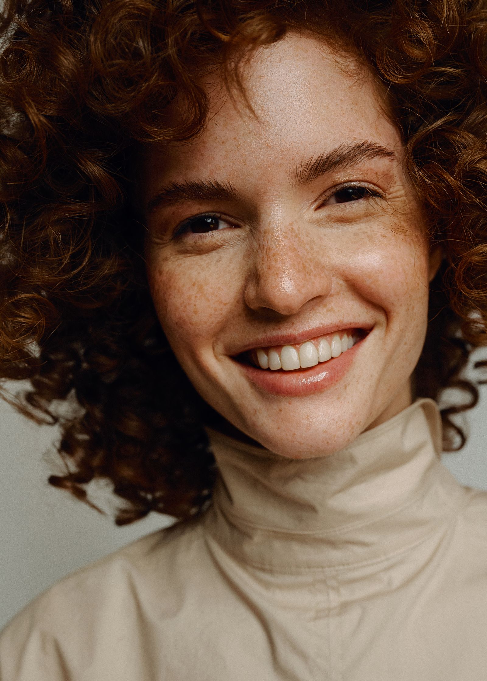 a woman with curly hair smiling