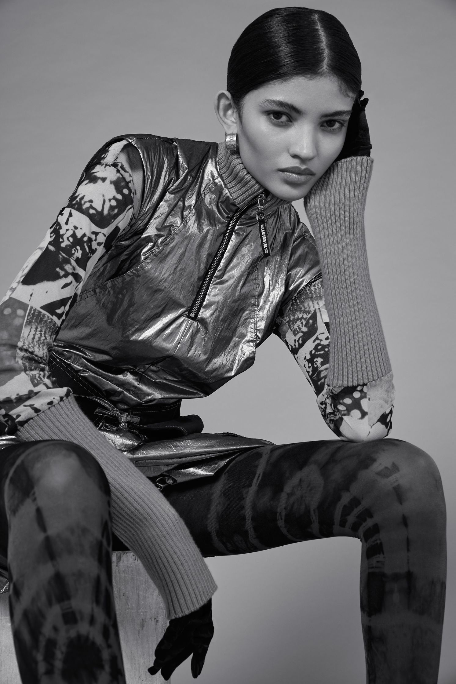 a black and white photo of a woman in a metallic outfit
