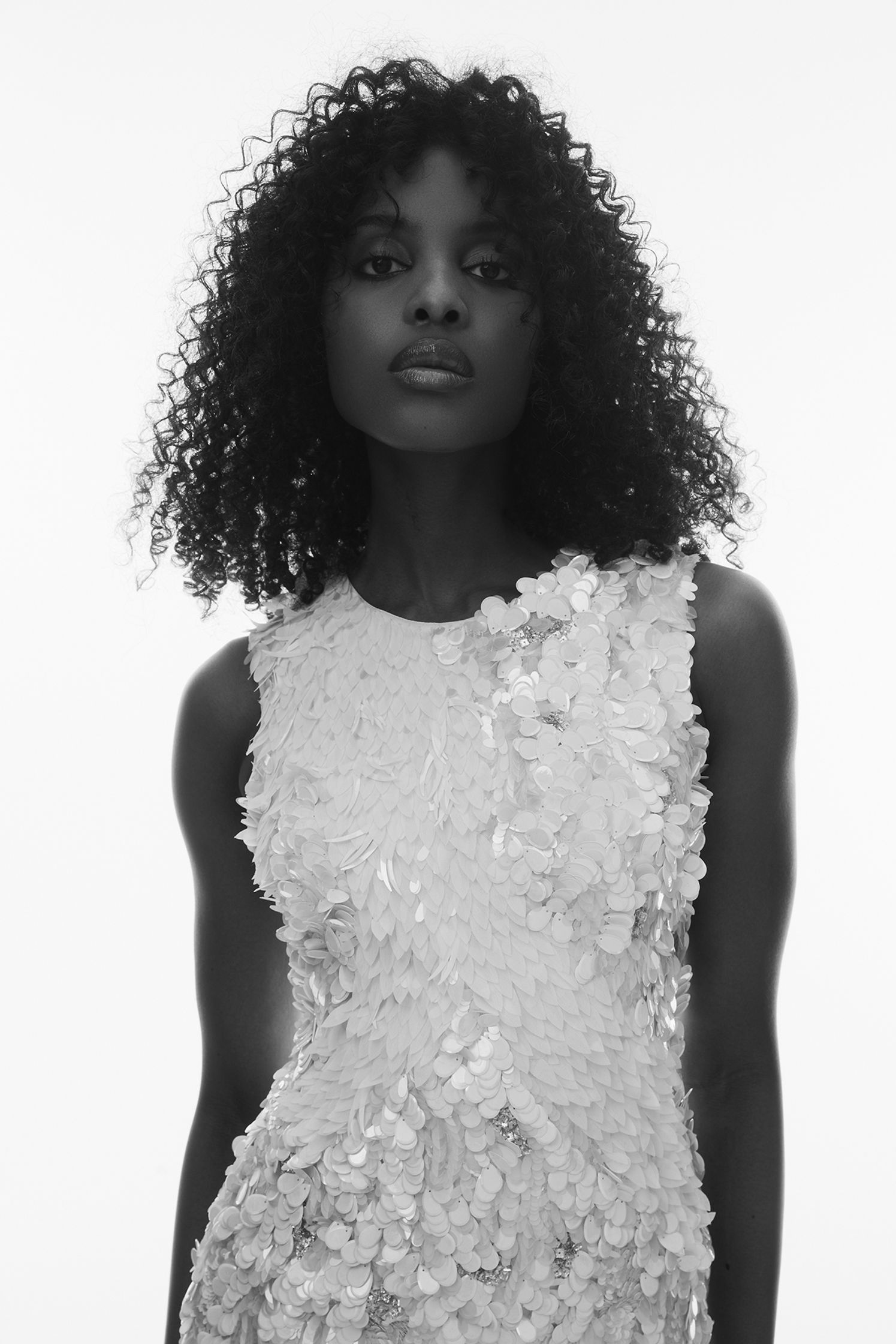 a black and white photo of a woman in a white dress