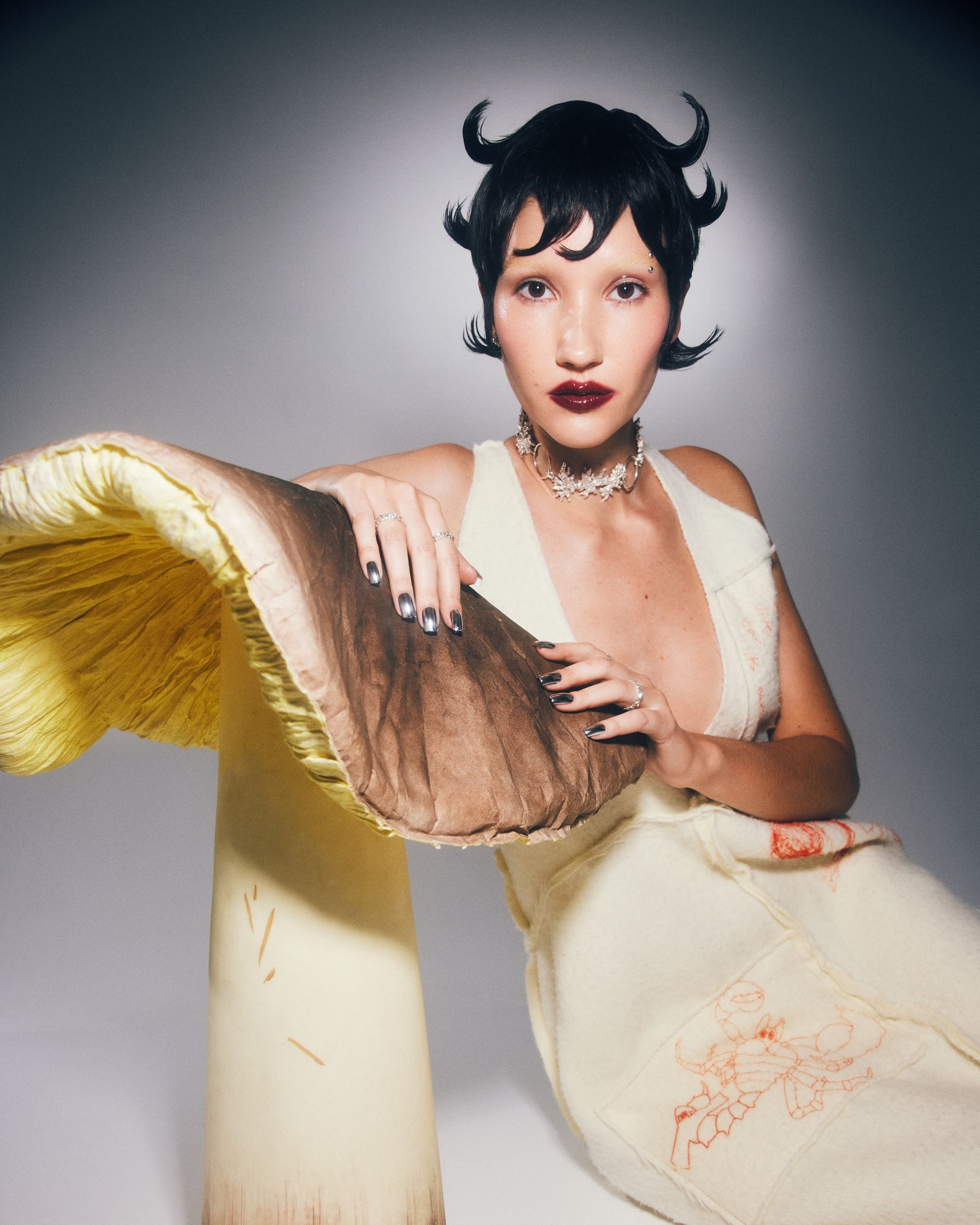 a woman is posing next to a large mushroom