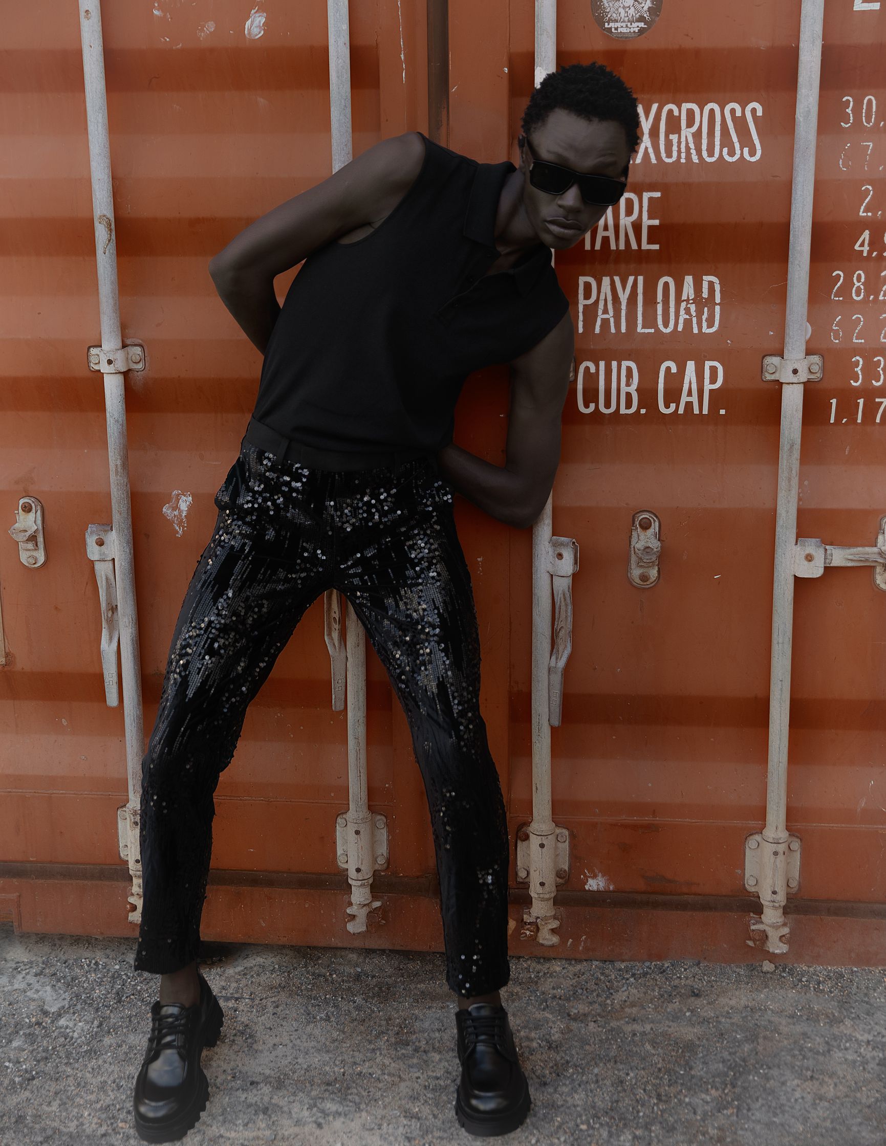 a man leaning against a shipping container