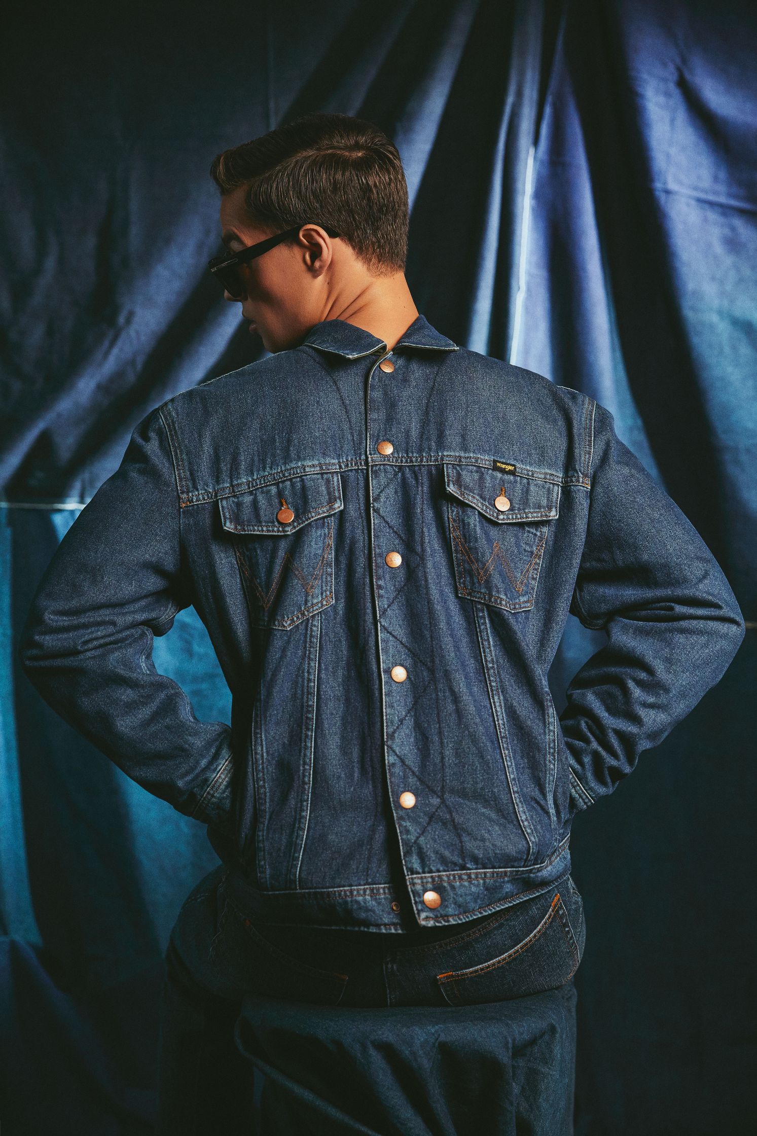 the back of a man wearing a denim jacket