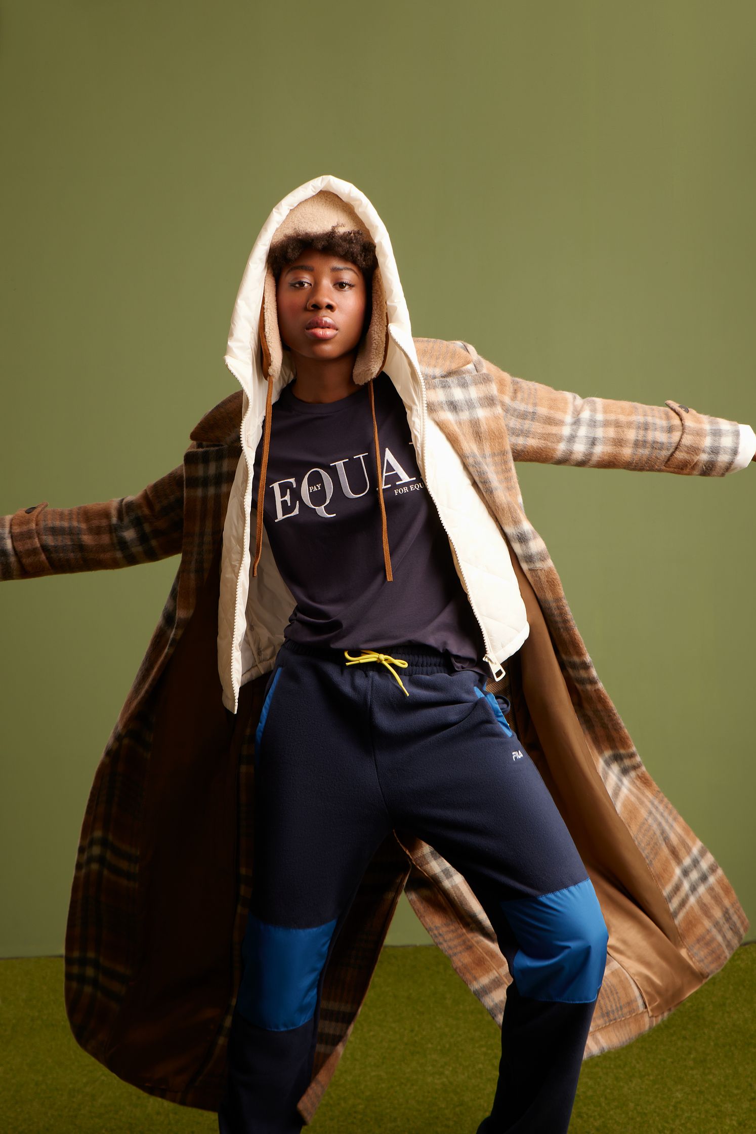 a black man in a coat and pants posing for a photo