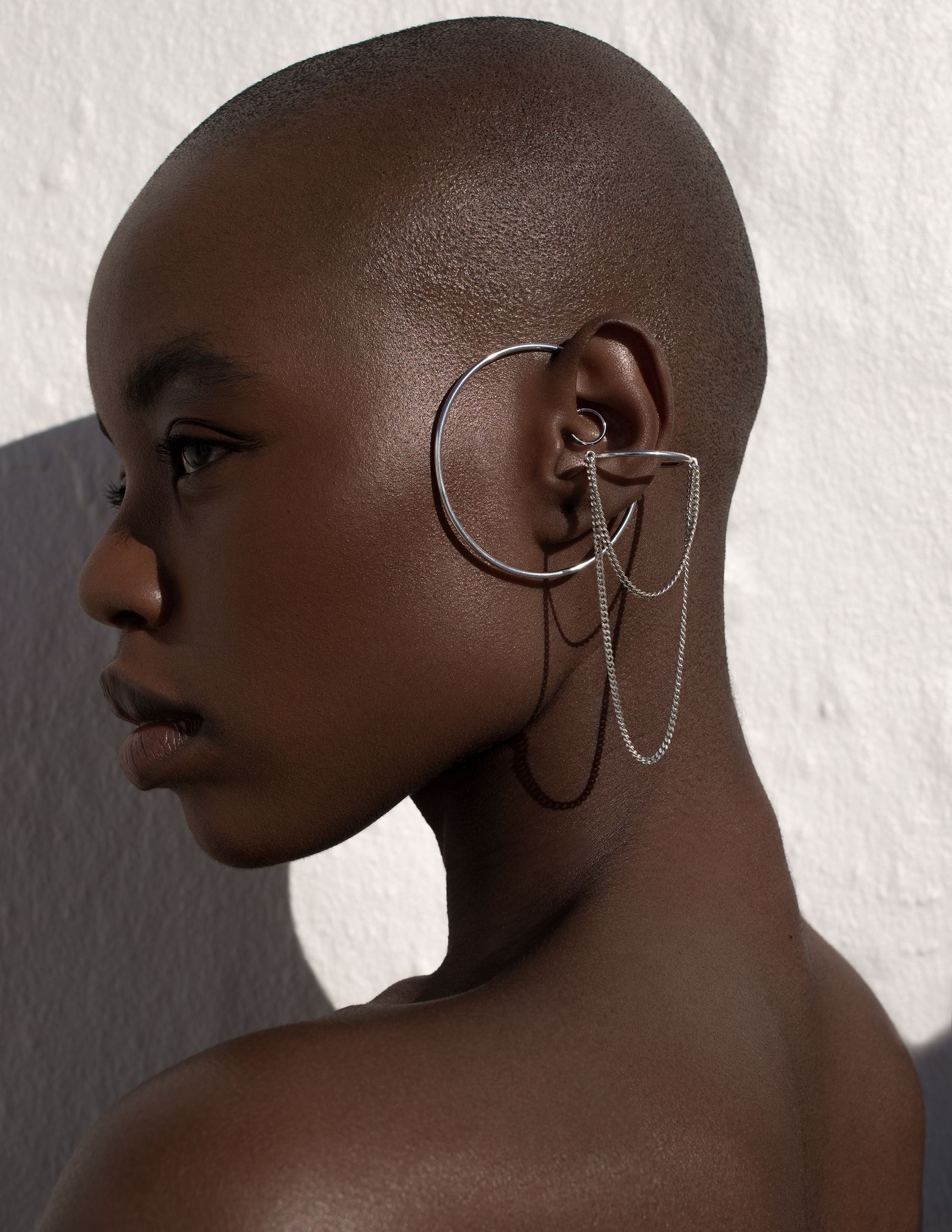 a black woman wearing a pair of ear cuffs