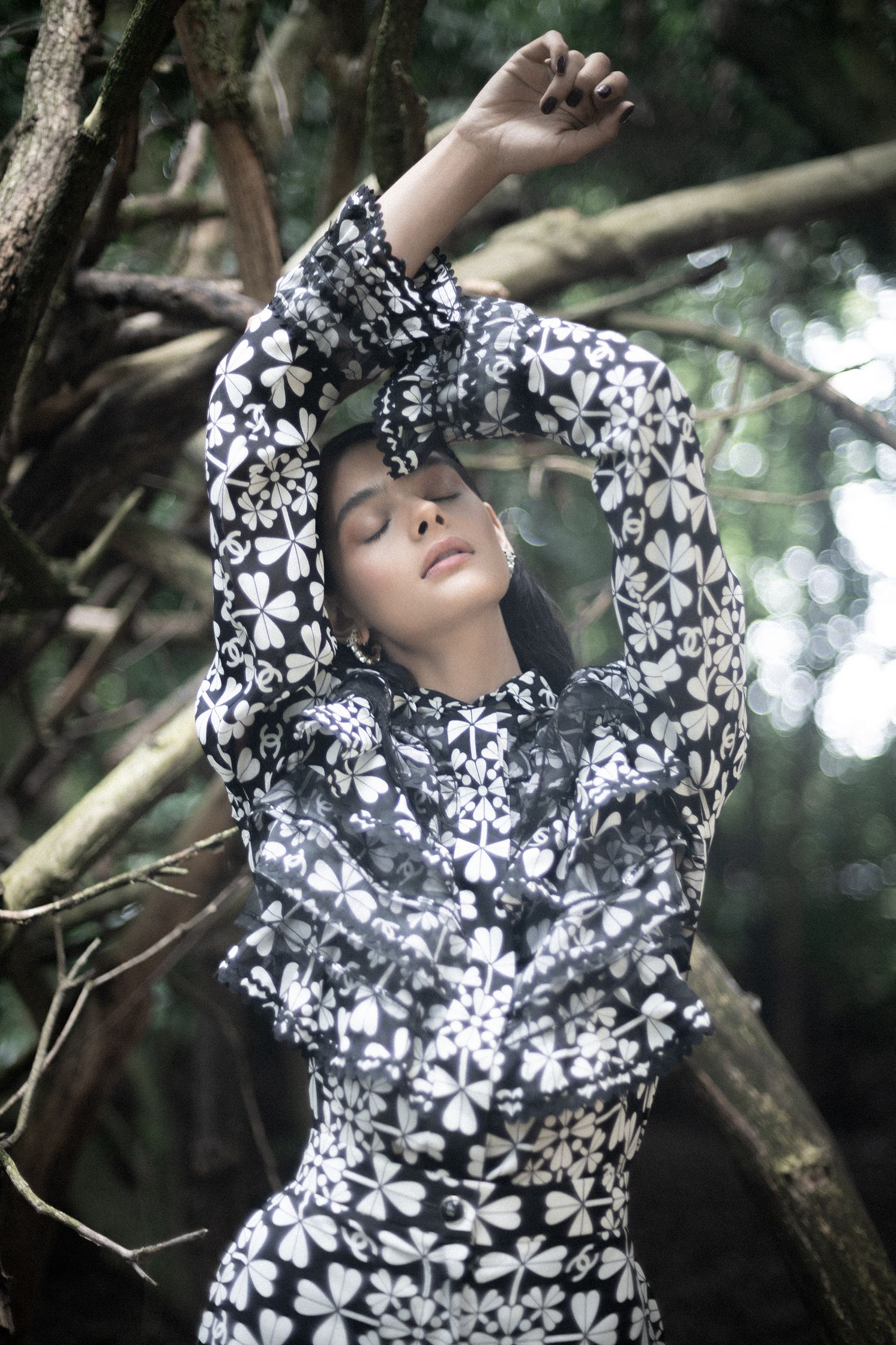 a woman in a black and white dress posing in the woods