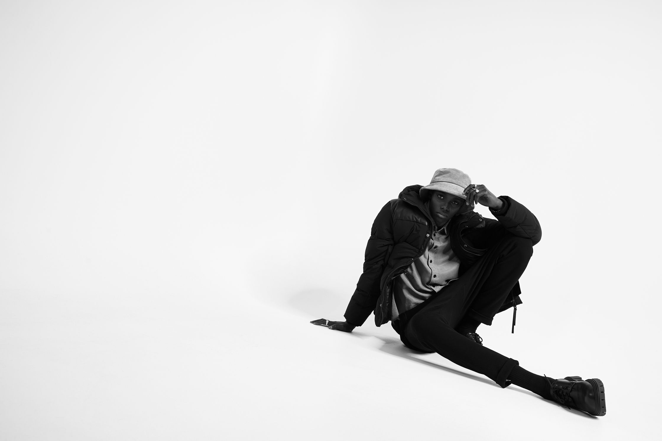 a black and white photo of a man sitting on the ground