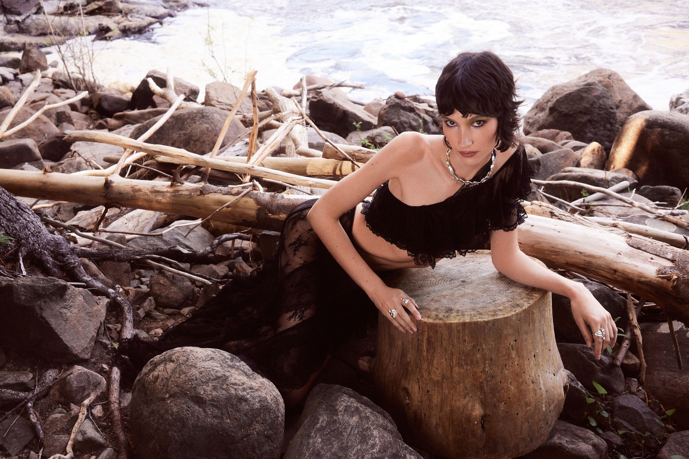 a woman sitting on top of a tree stump