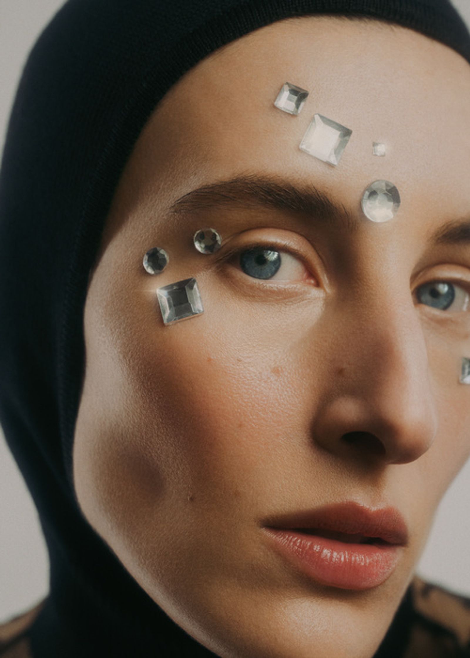 a woman wearing a hijab with crystals on her face