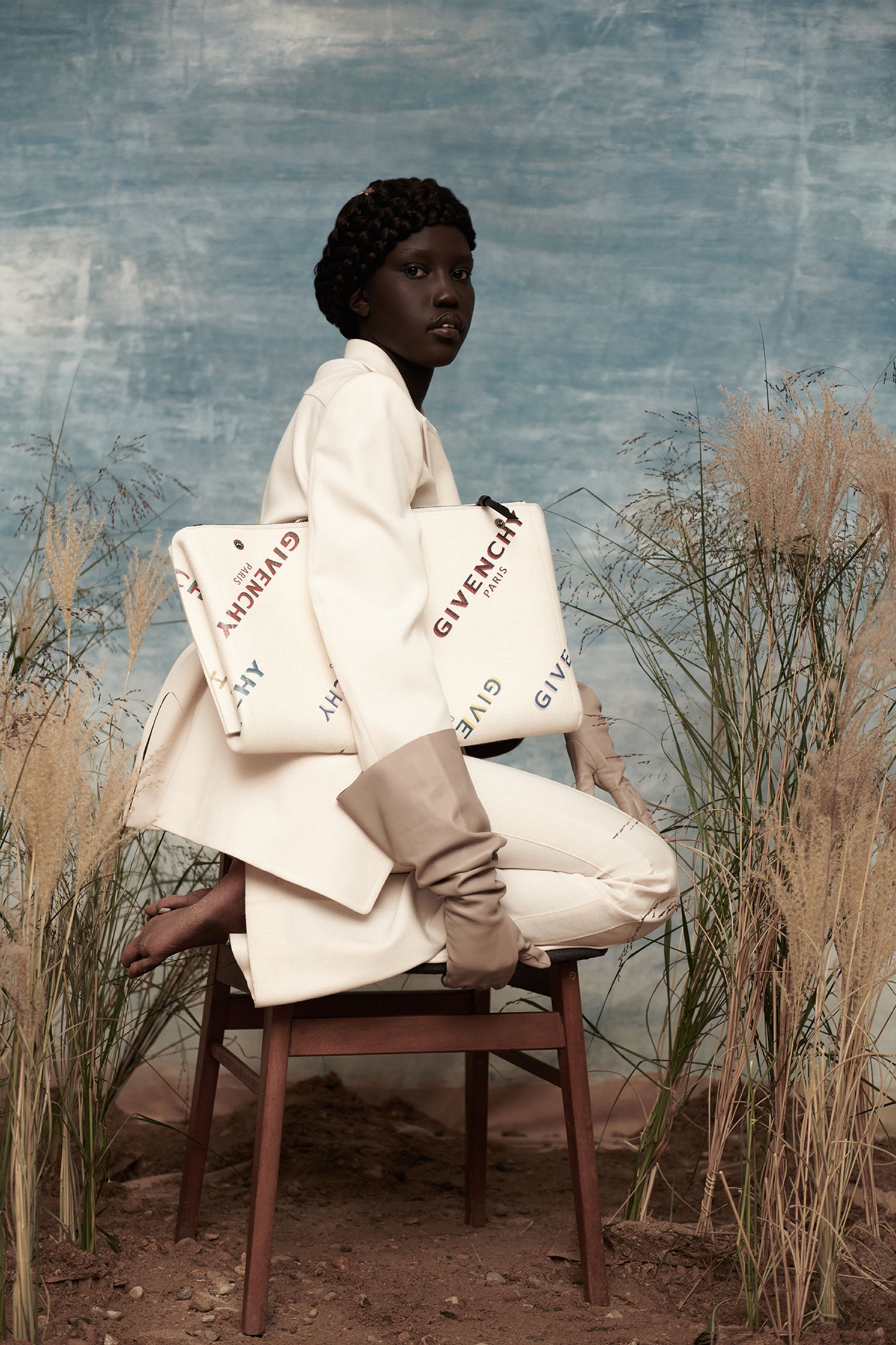 a woman sitting on a chair holding a bag