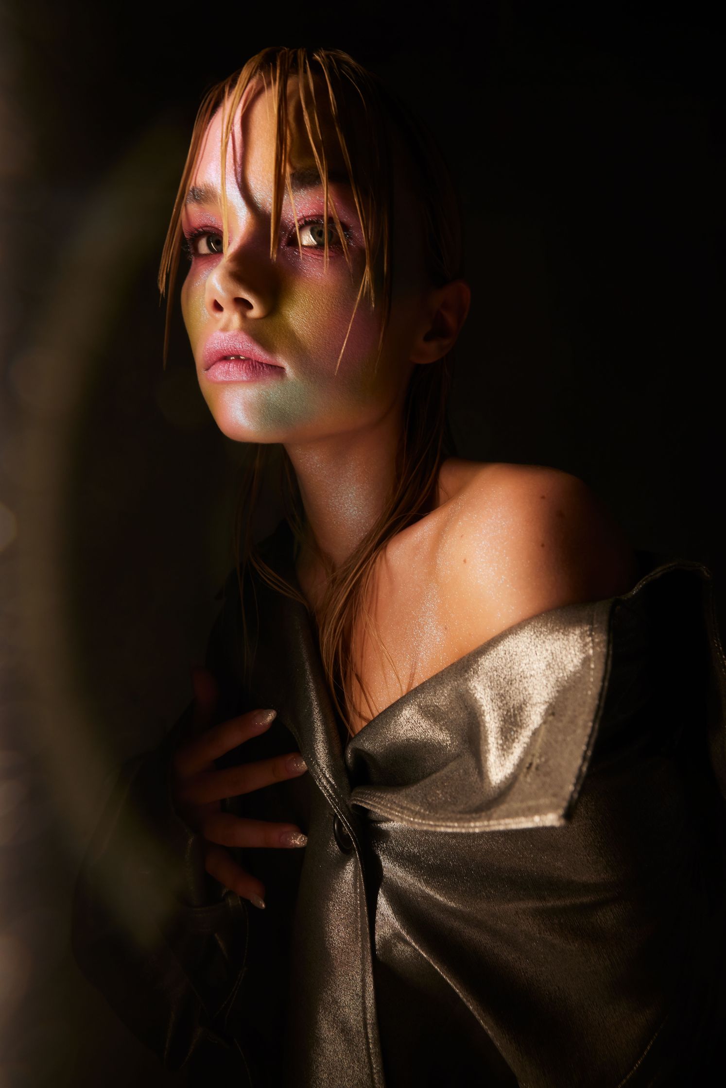 a woman in a leather jacket is posing in front of a light