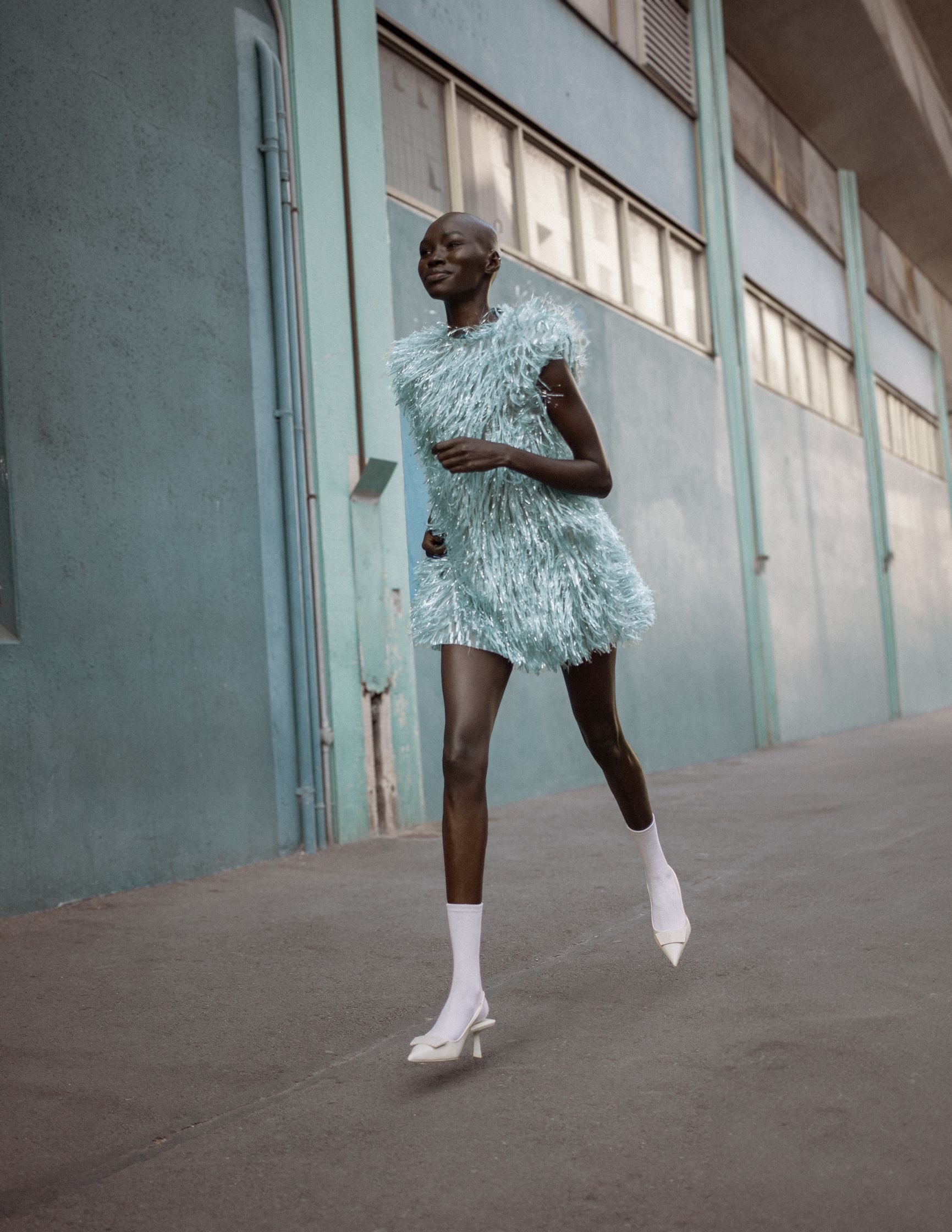 a woman in a blue dress is running down the street