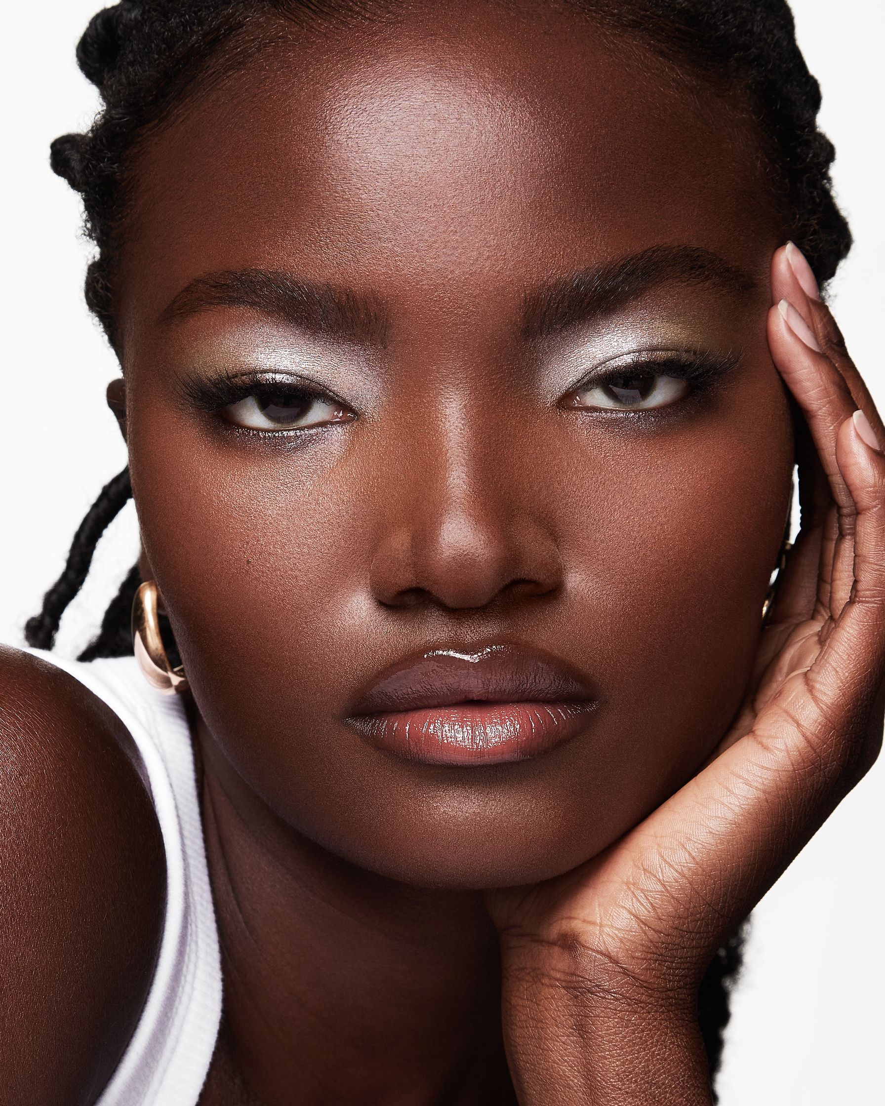 a black woman with dreadlocks posing with her hand on her face