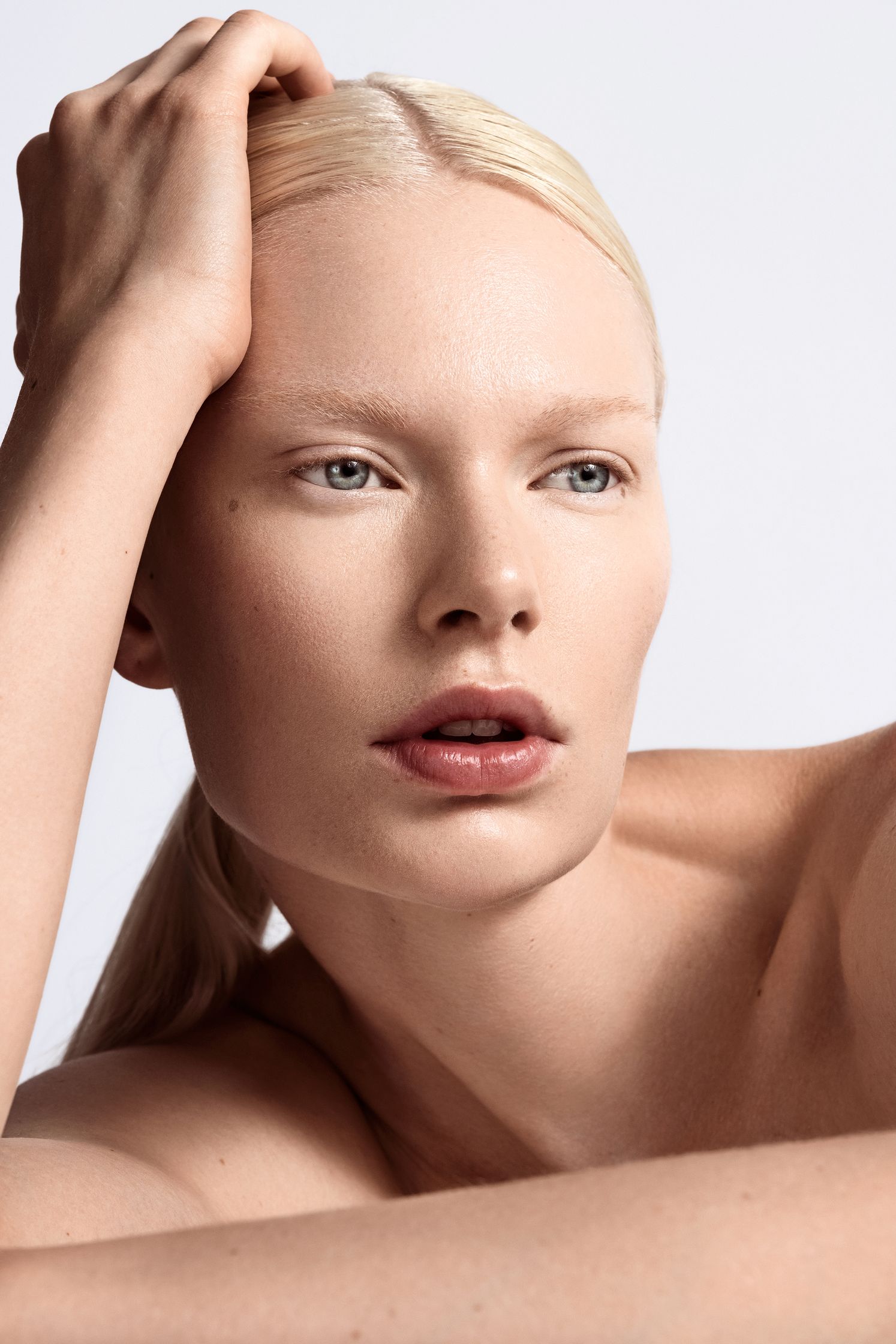 a blond woman posing with her hands on her head