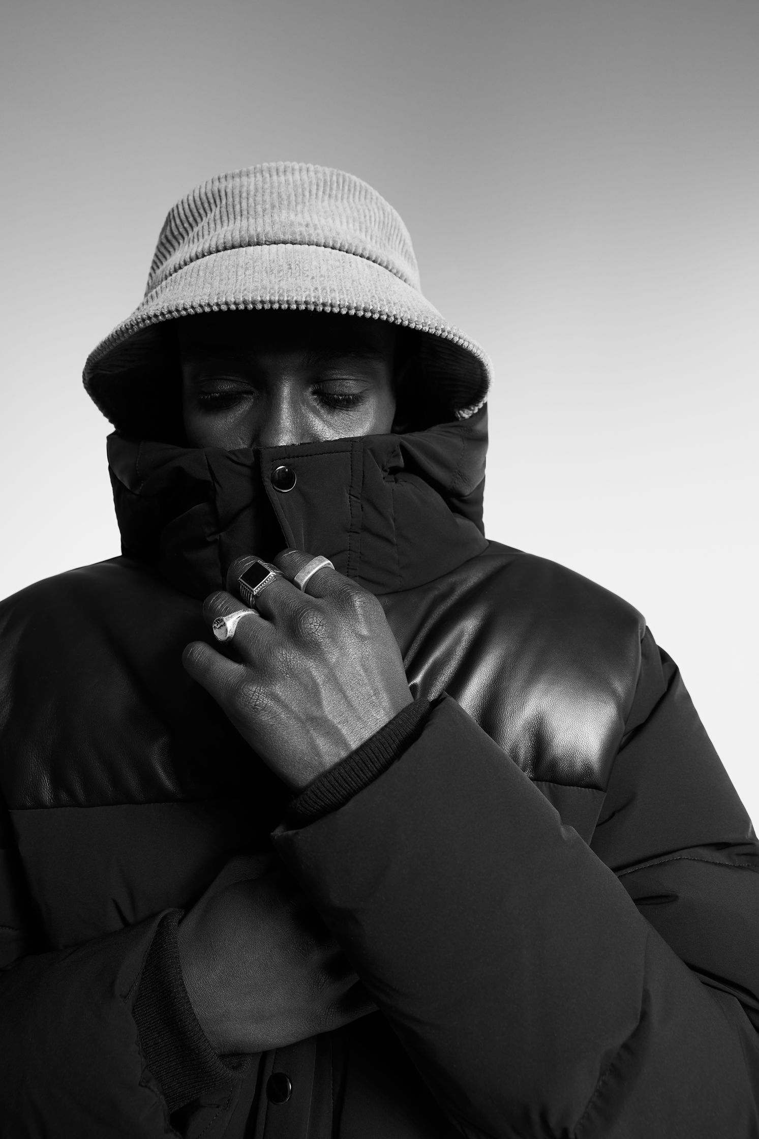 a black and white photo of a man wearing a jacket and hat
