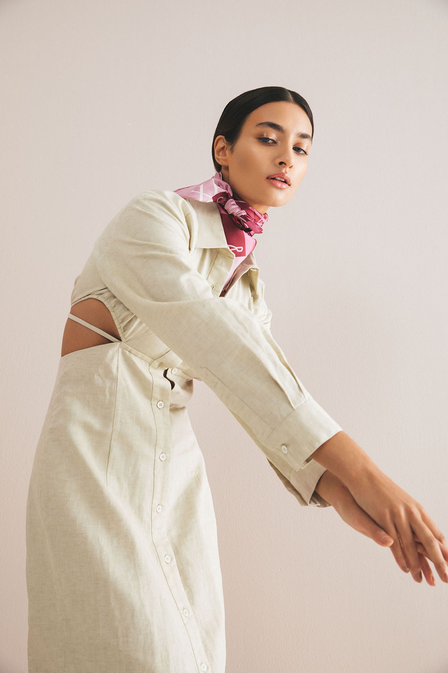 a woman in a white dress with a pink scarf
