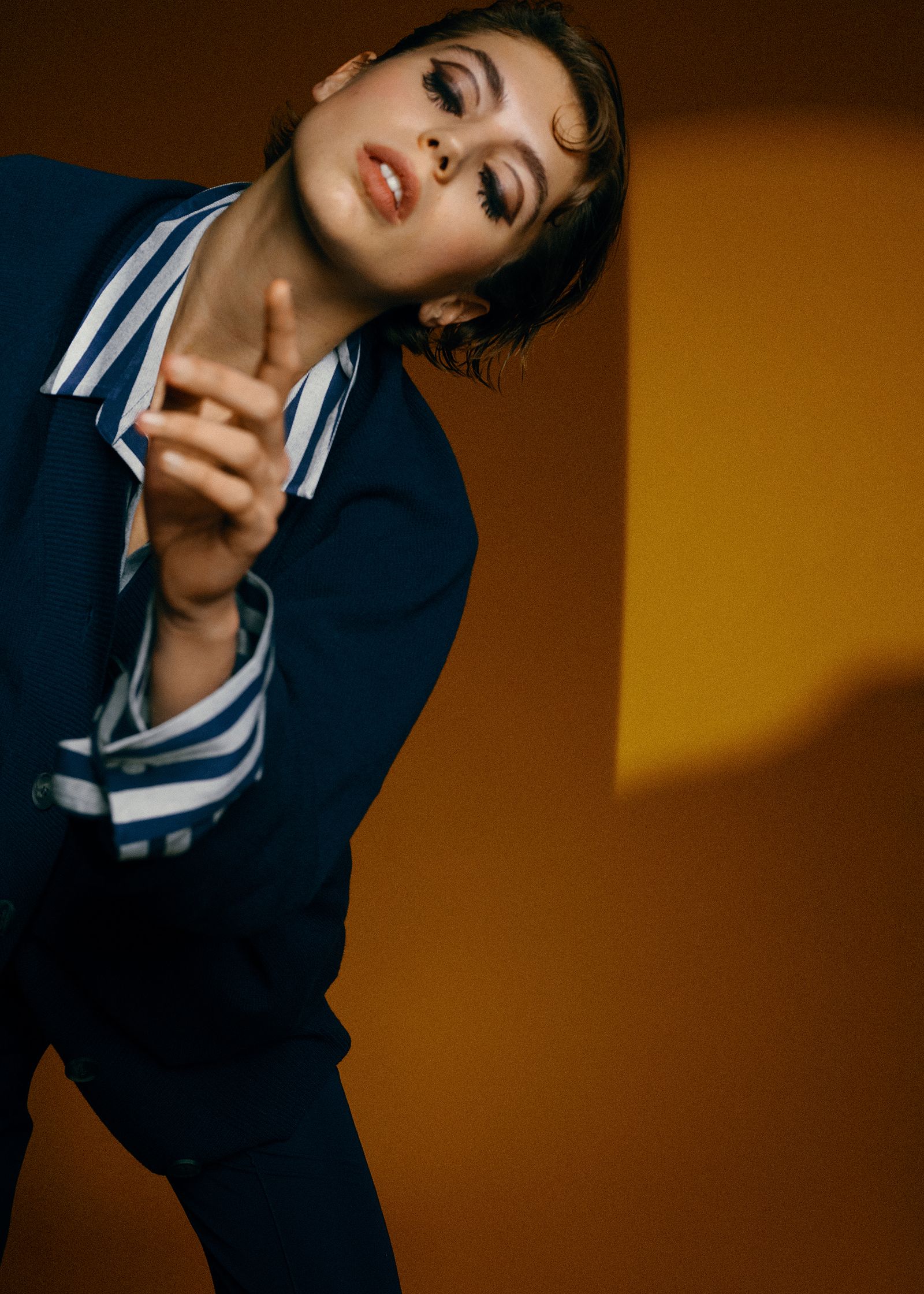a woman in a blue jacket pointing her finger
