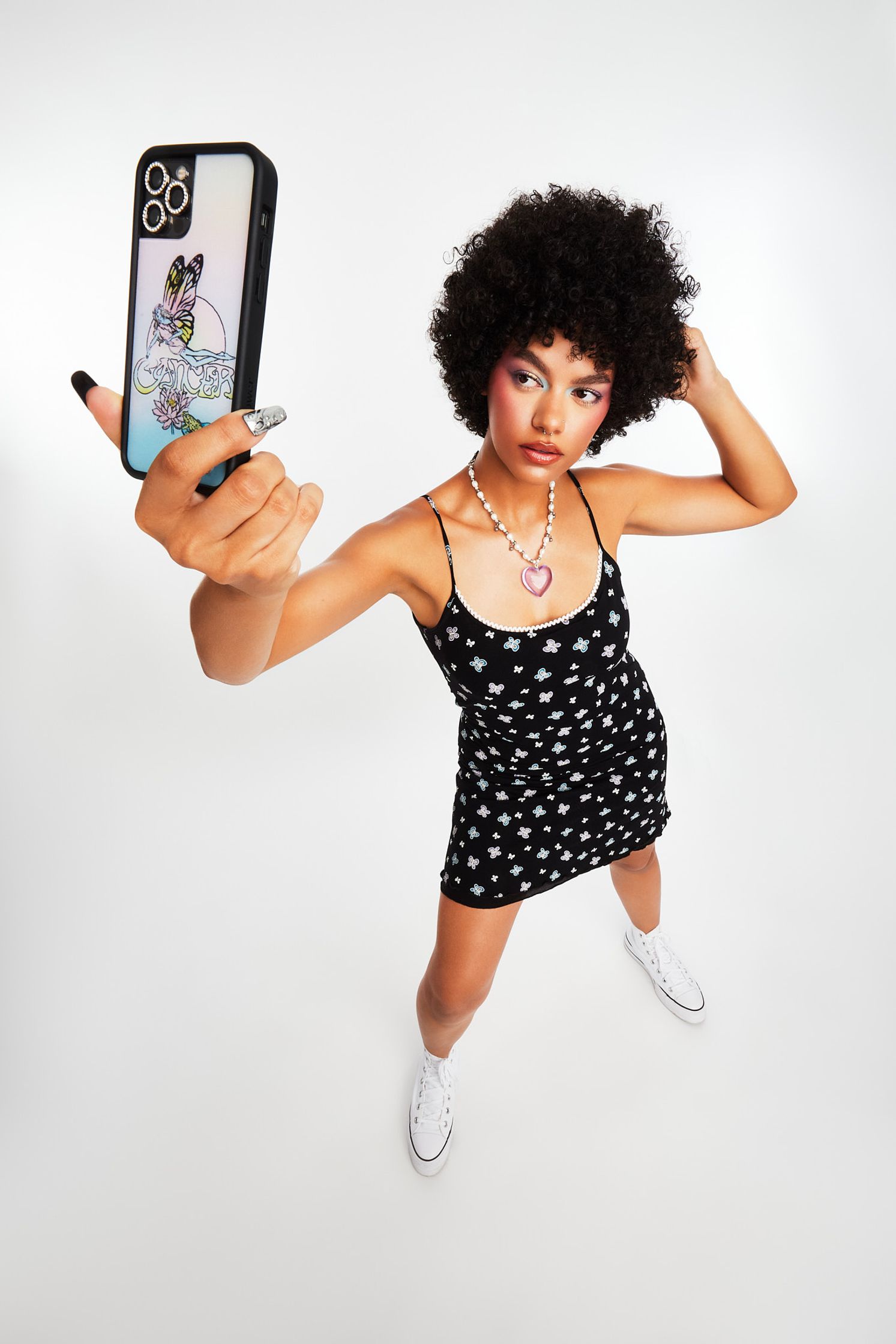 a woman in a black dress holding a phone