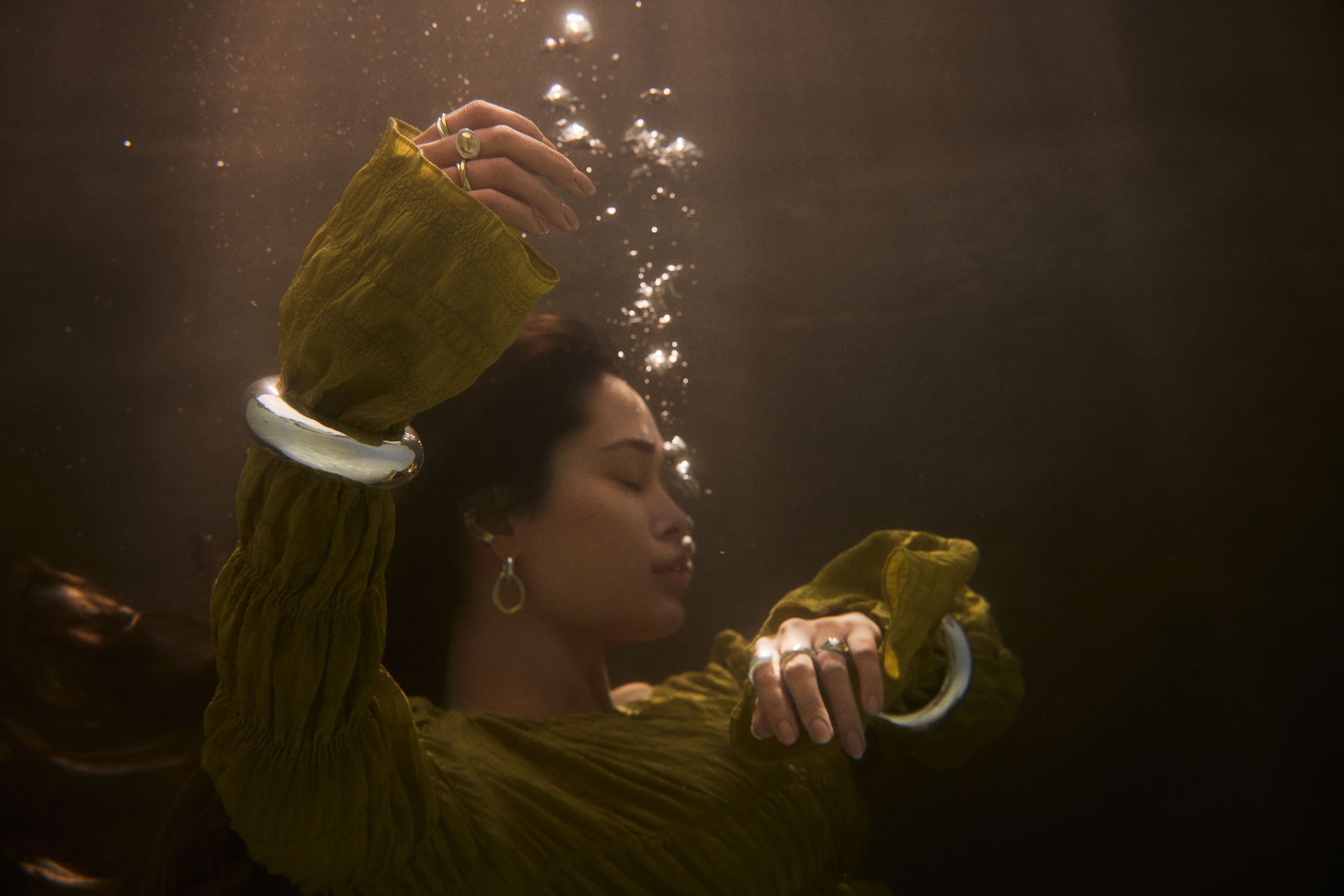 a woman in a green dress floating under water