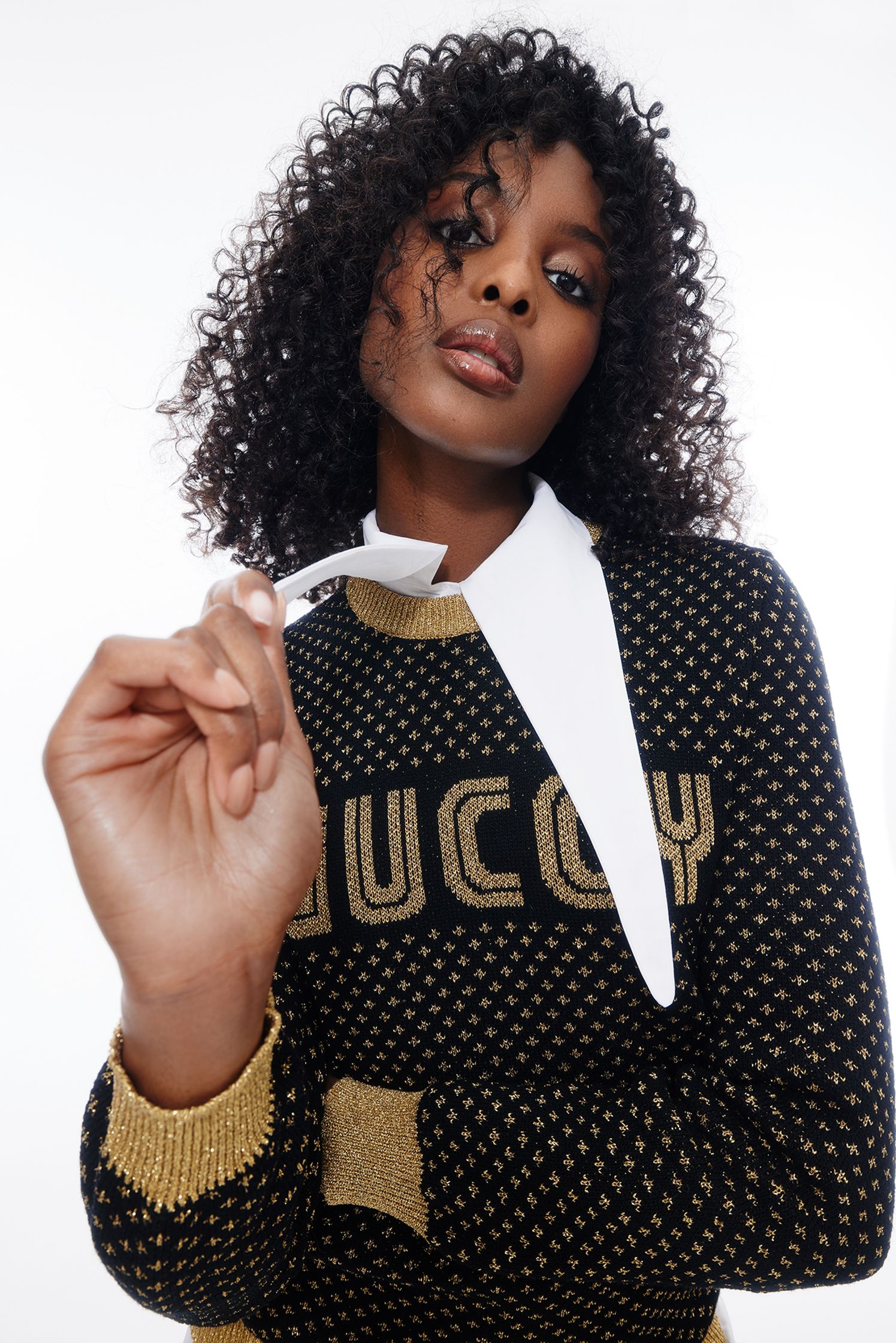 a black woman wearing a sweater with the word lucy on it