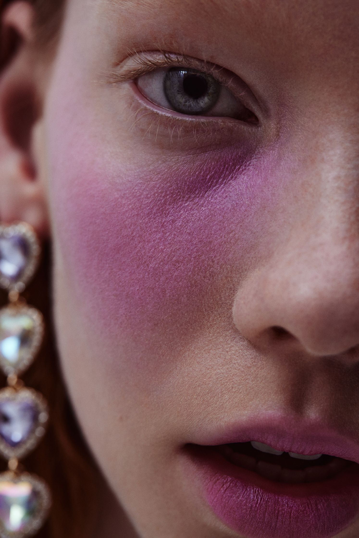 a close up of a woman with pink makeup on her face