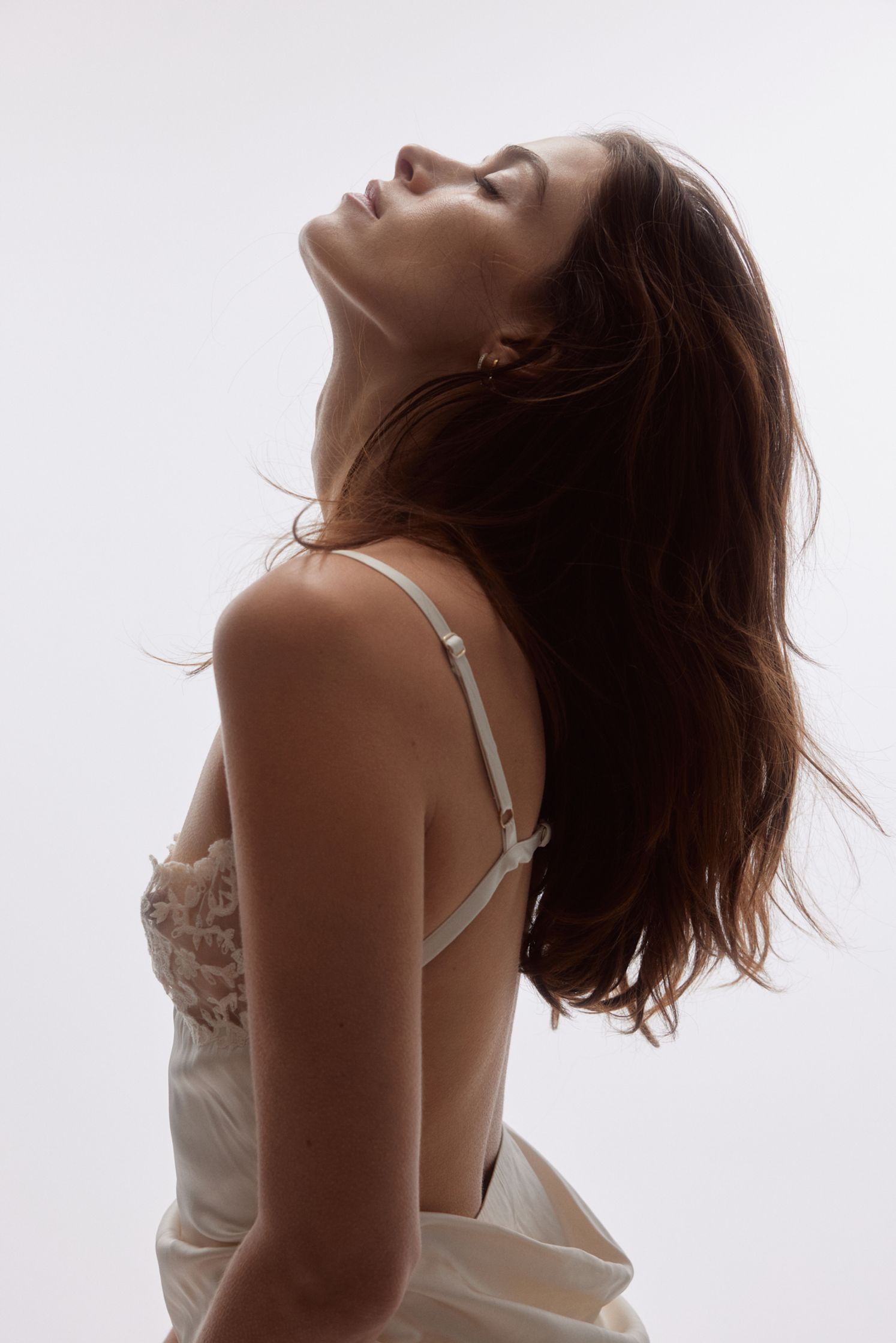 a woman in a white dress with her eyes closed