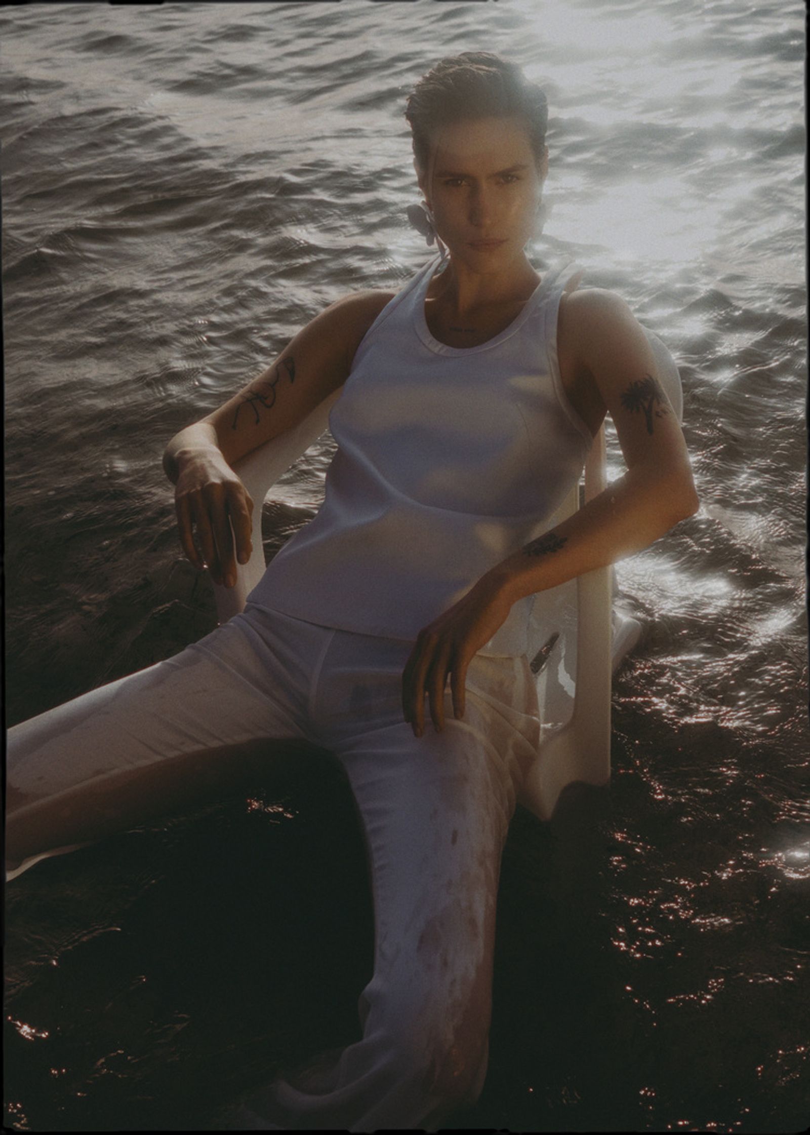 a woman sitting on a chair in the water