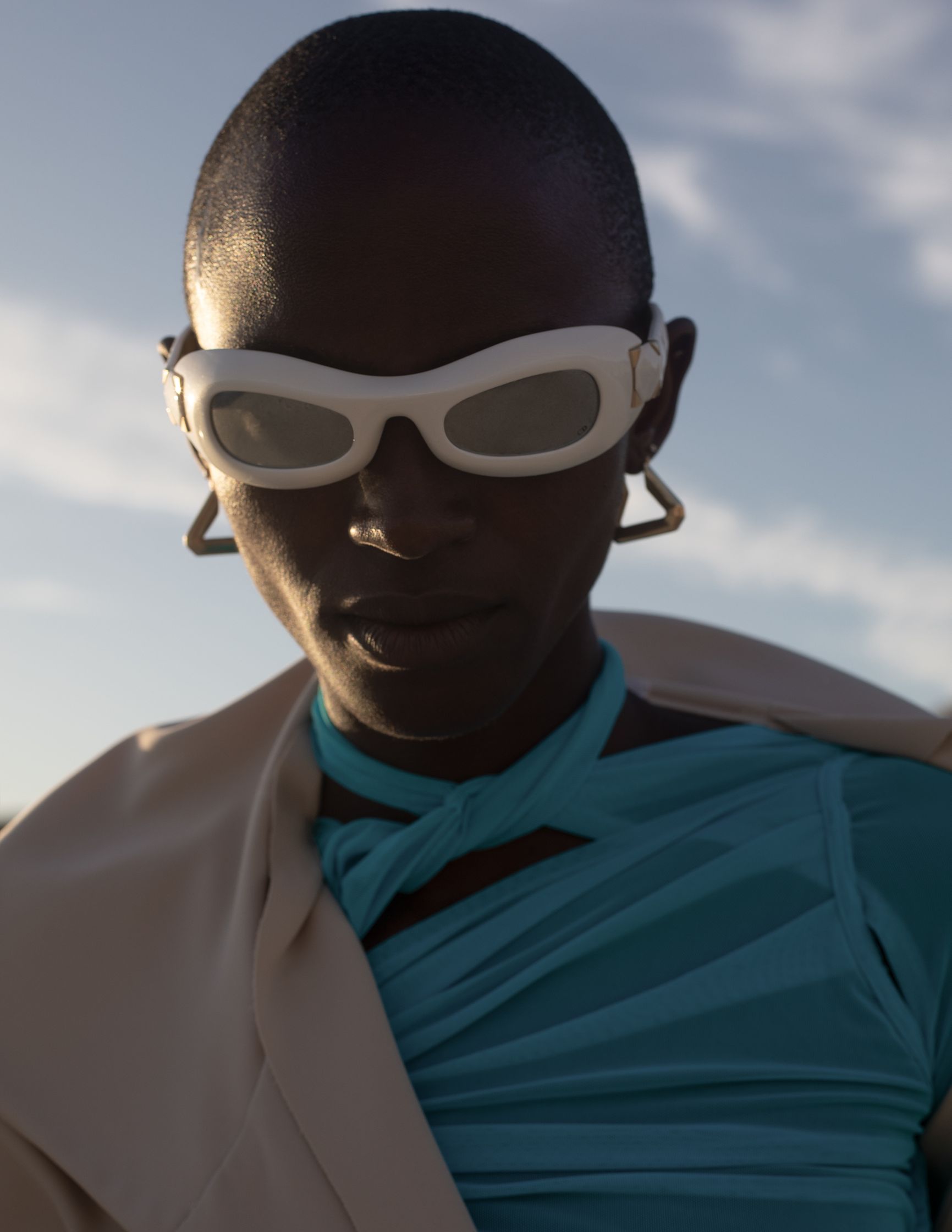 a woman wearing sunglasses and a blue top