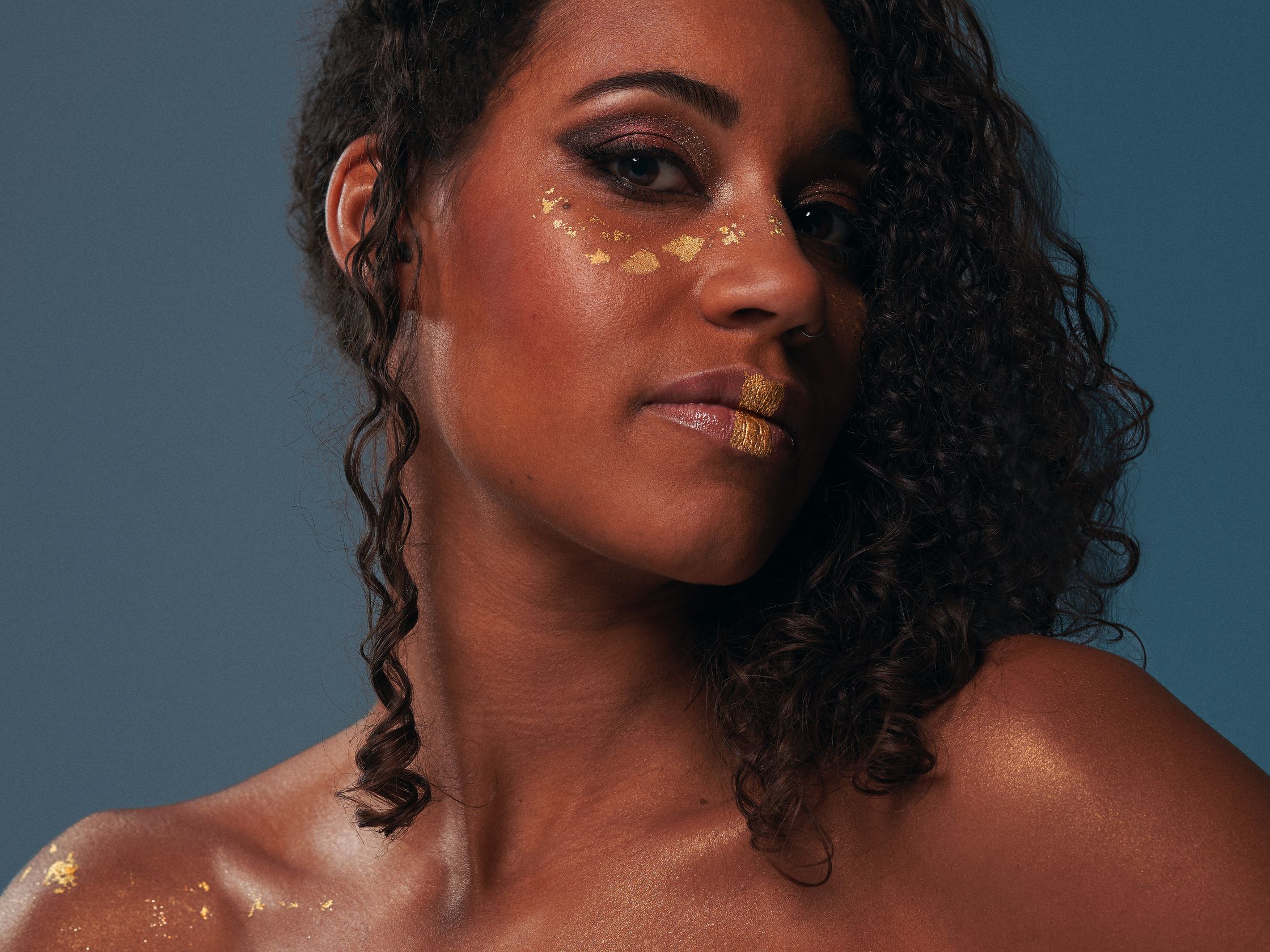 a woman with gold paint on her face