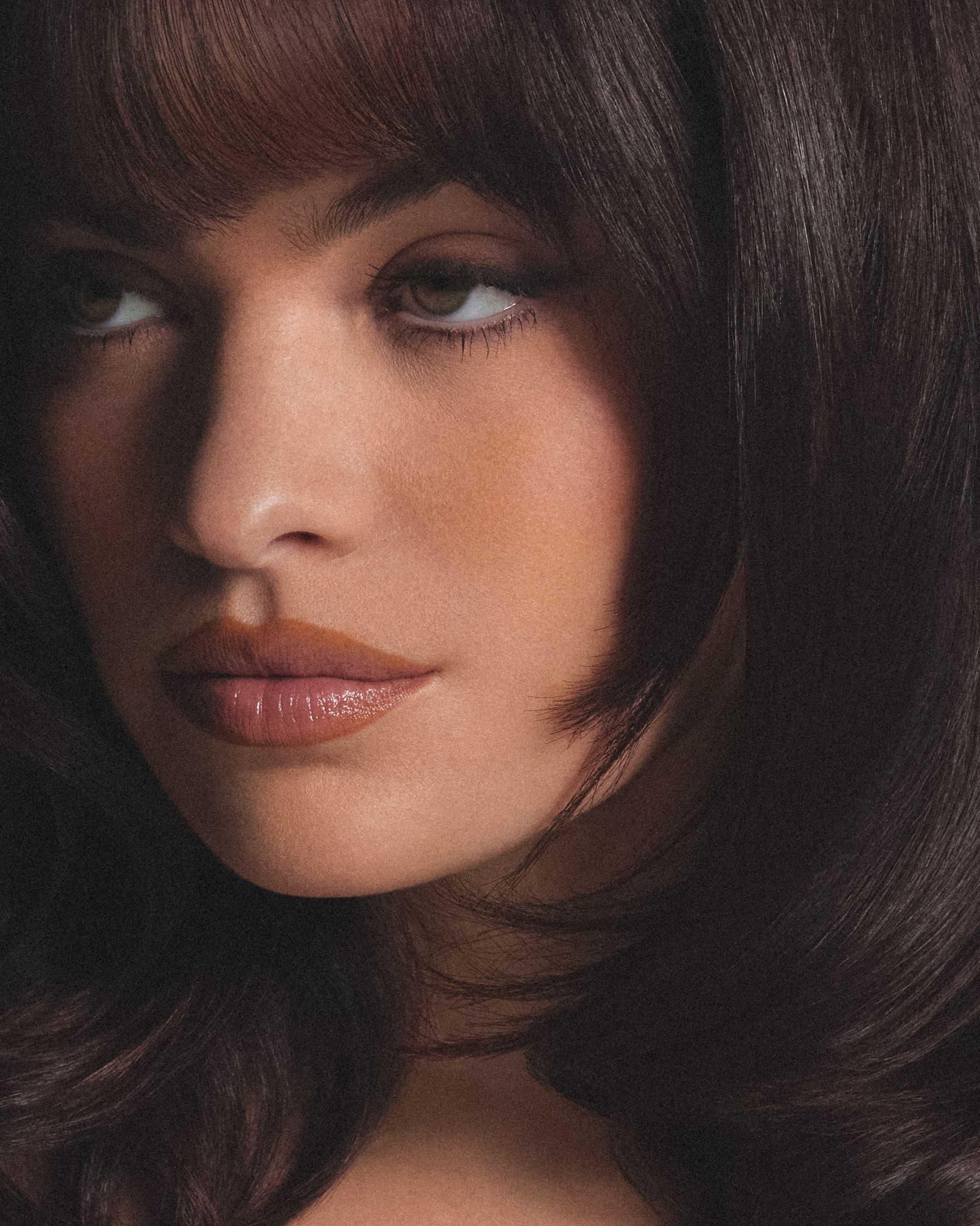 a woman with dark brown hair and bangs