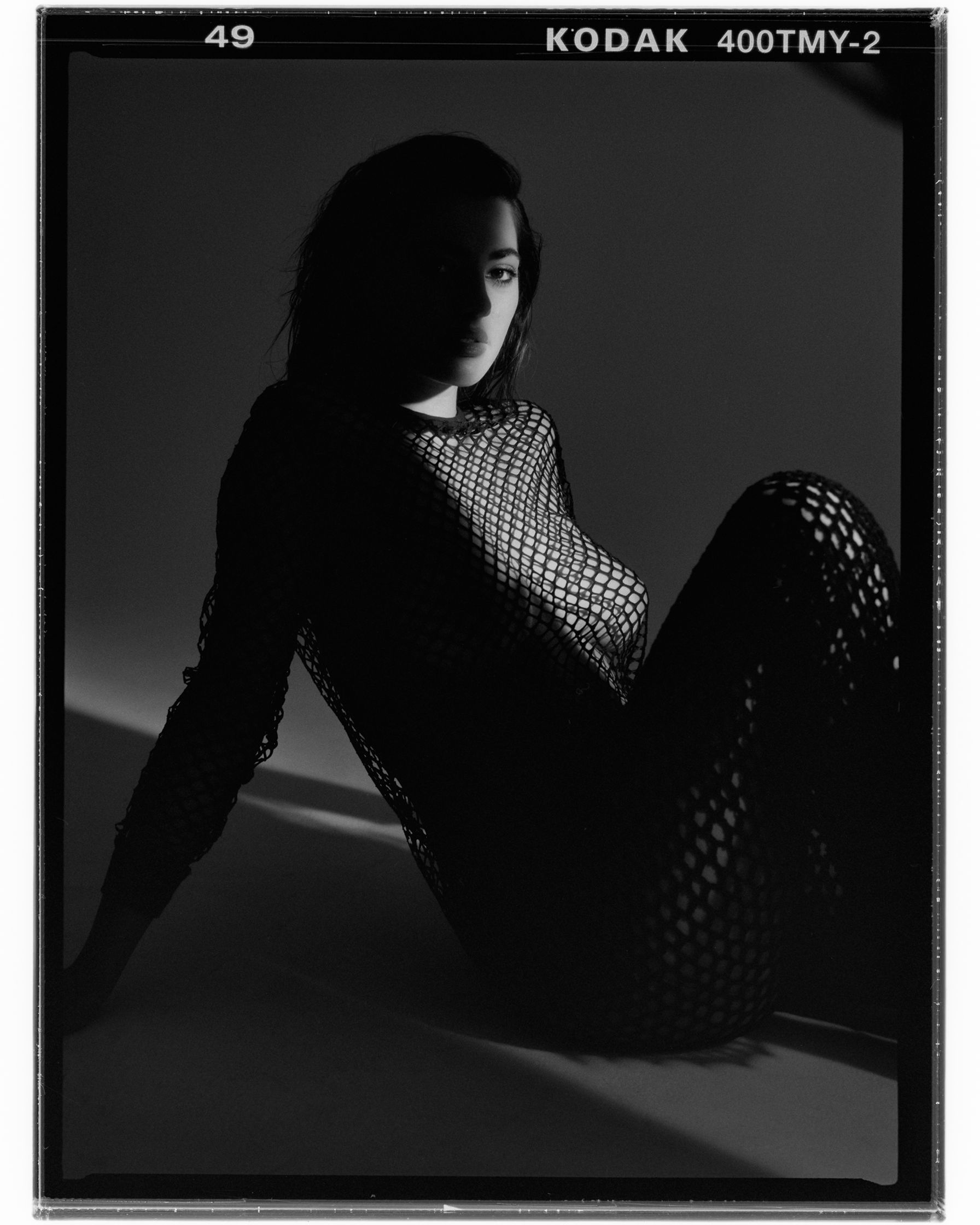 a black and white photograph of a woman in a netted dress