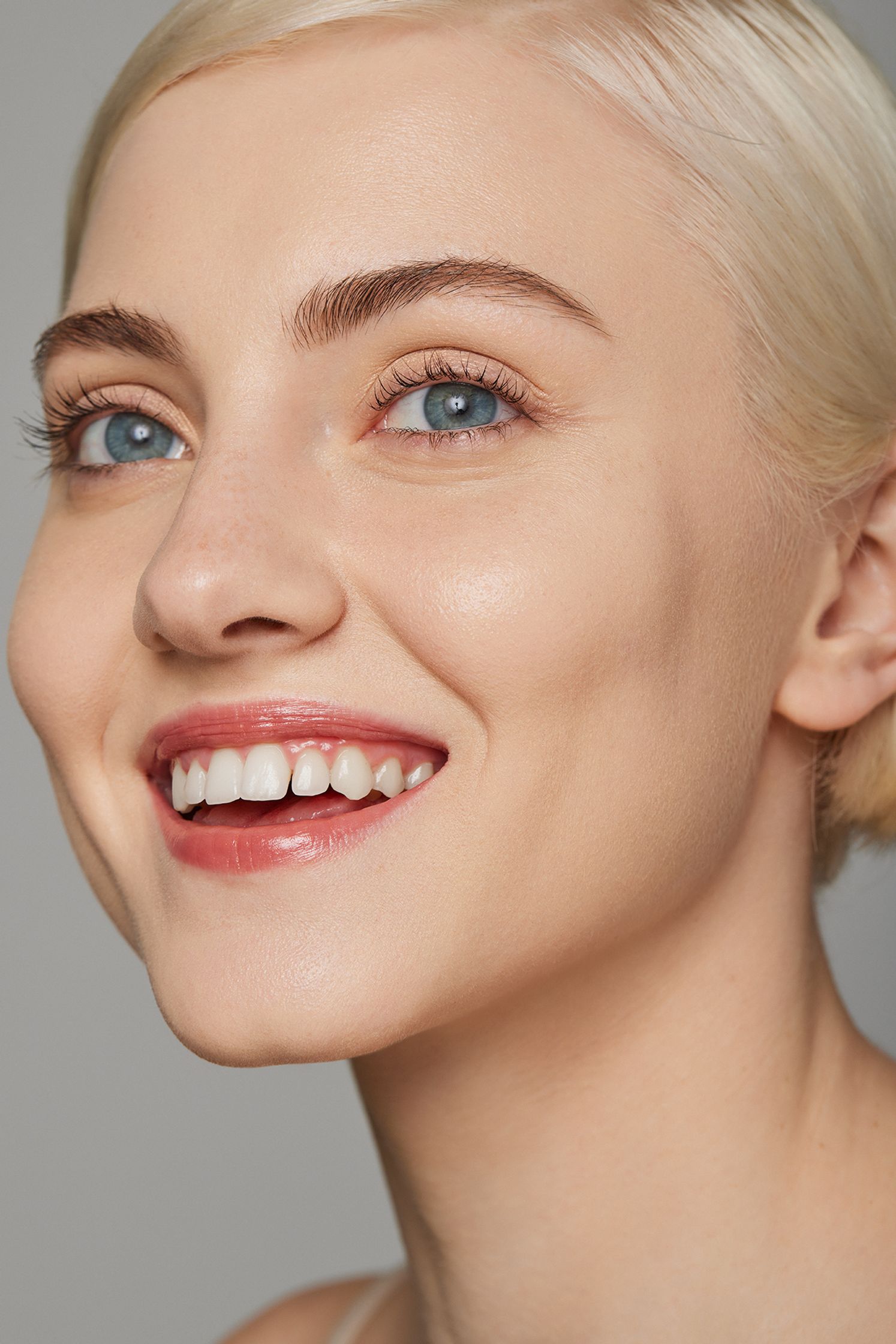 a woman with blond hair and blue eyes is smiling