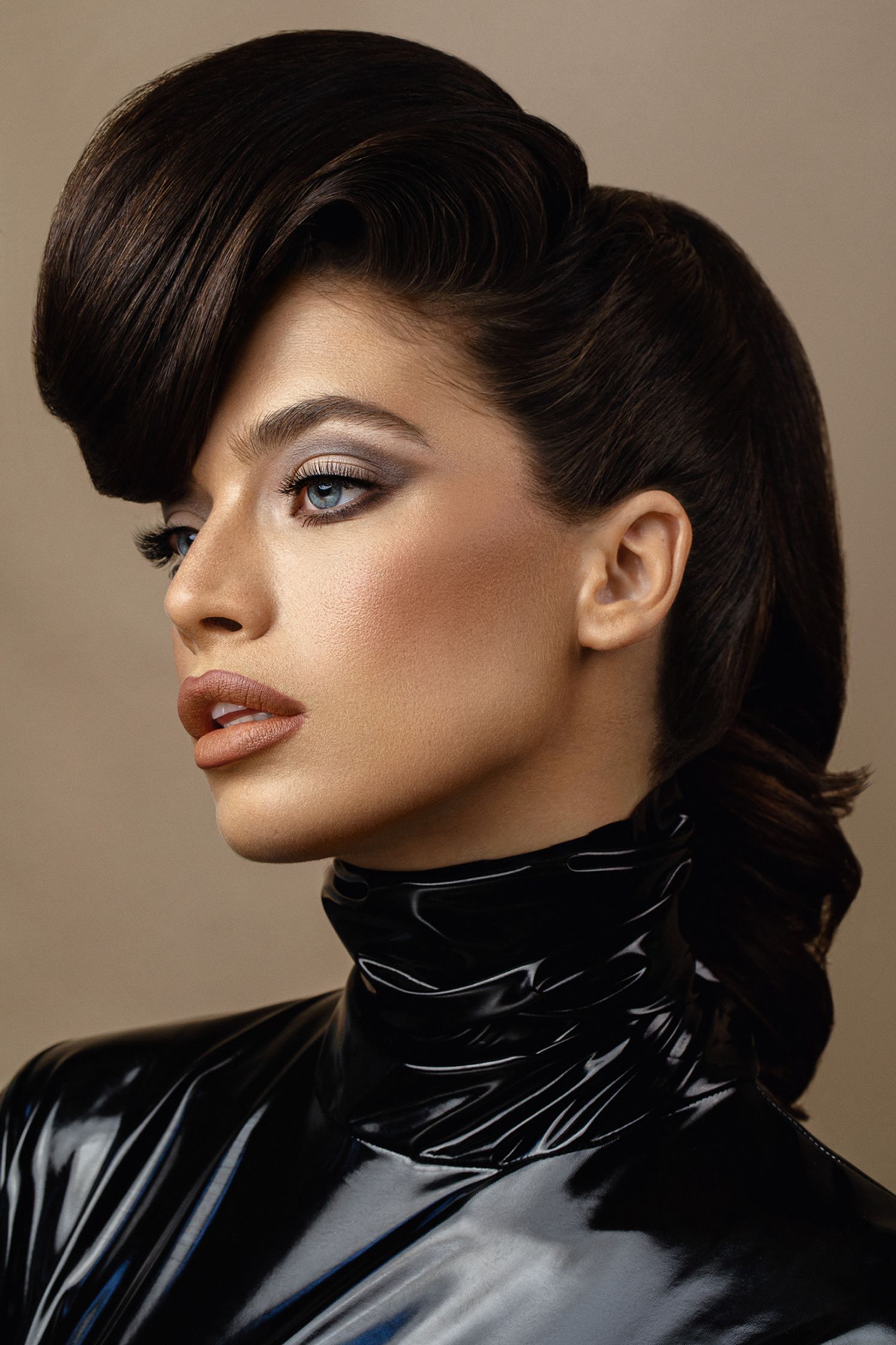 a woman in a black leather jacket with a ponytail