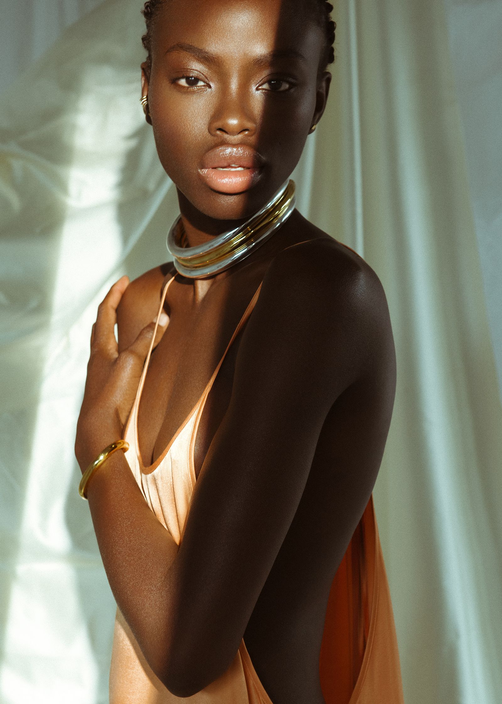 a black woman in an orange dress posing for a photo